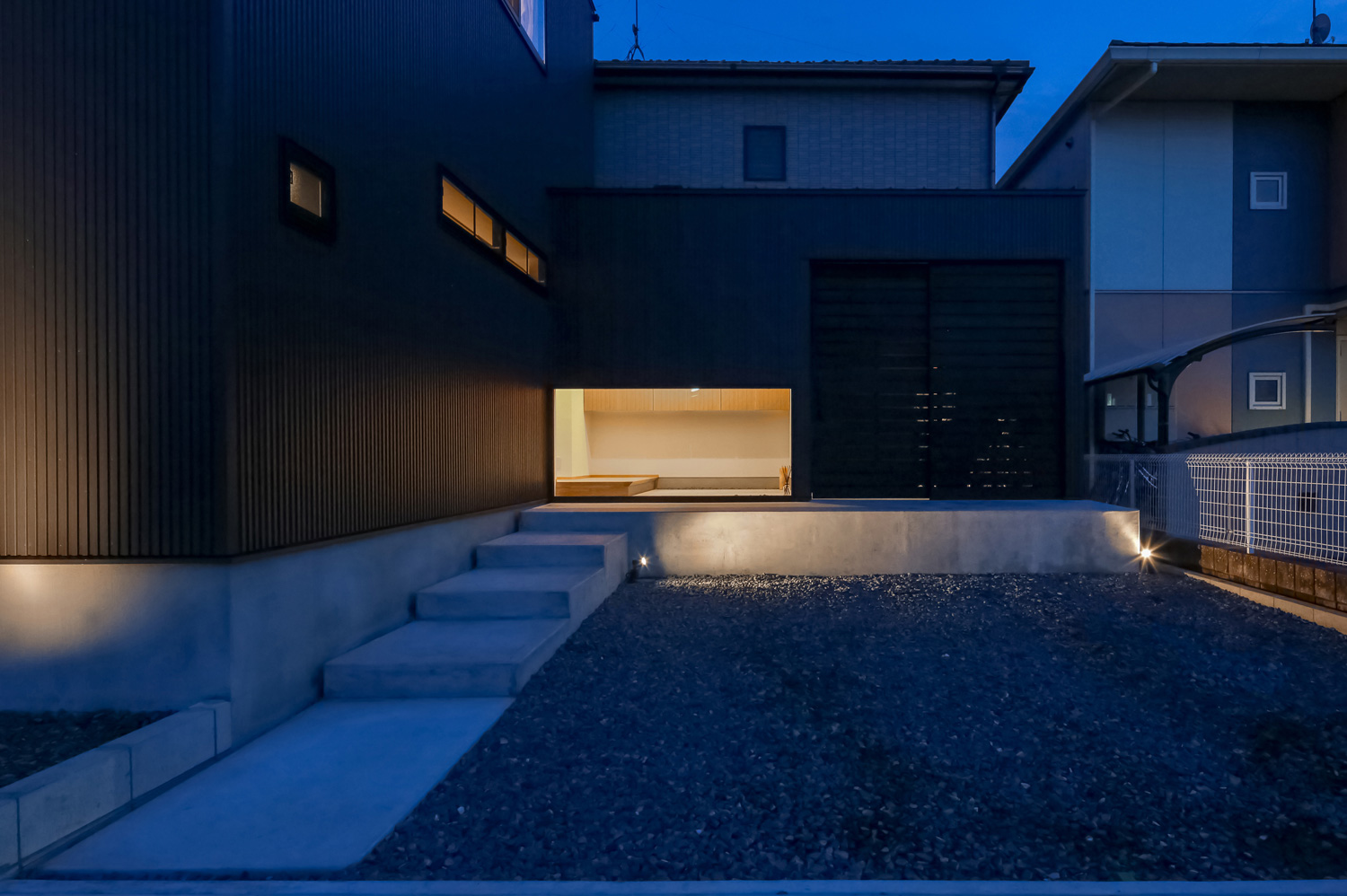 駐車場とコンクリートの階段アプローチがあるスタイリッシュな外観の家・デザイン住宅