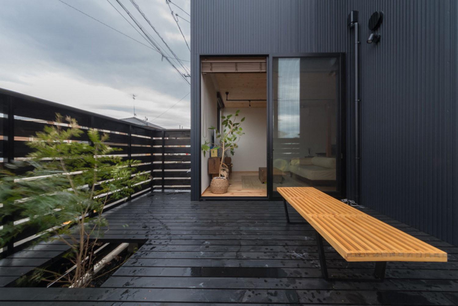 植栽とベンチがあるルーバーの目隠し壁に囲まれたテラス・デザイン住宅