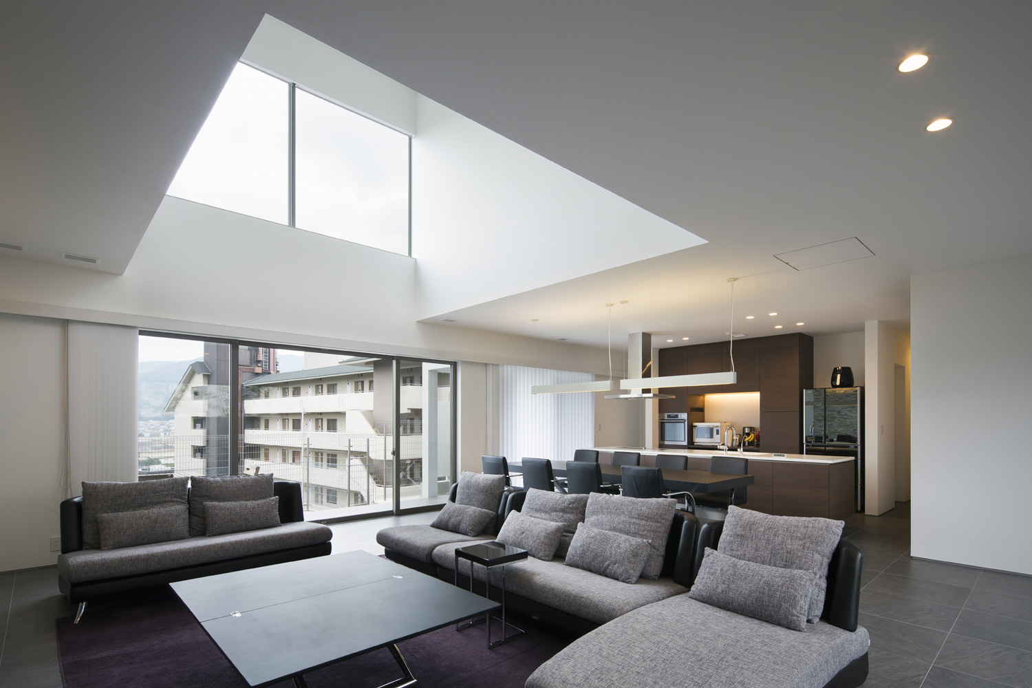 部屋の真ん中に吹き抜けがある大きな窓がある二階LDK・デザイン住宅