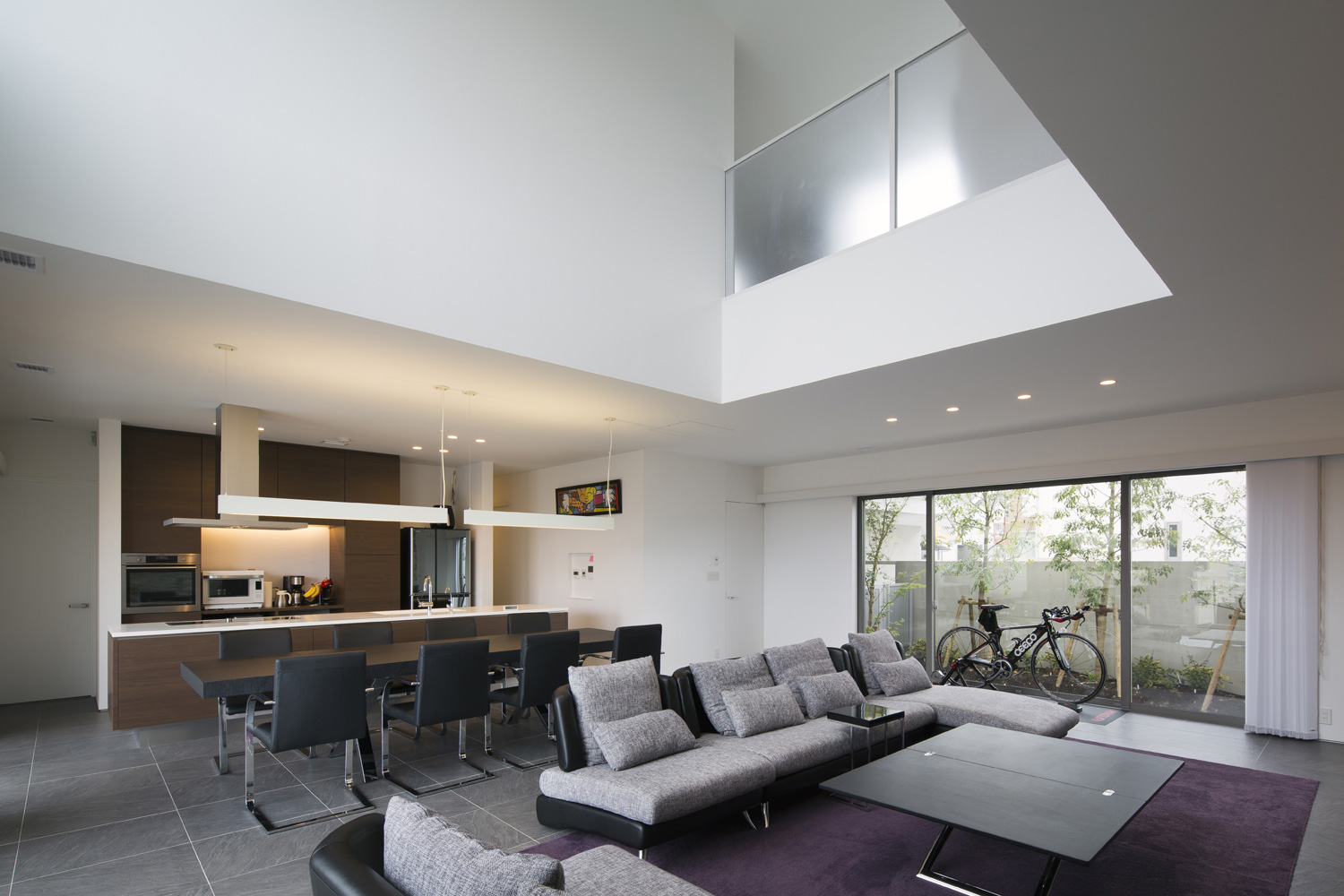 植栽が見える窓と吹き抜けがある大空間のLDK・デザイン住宅