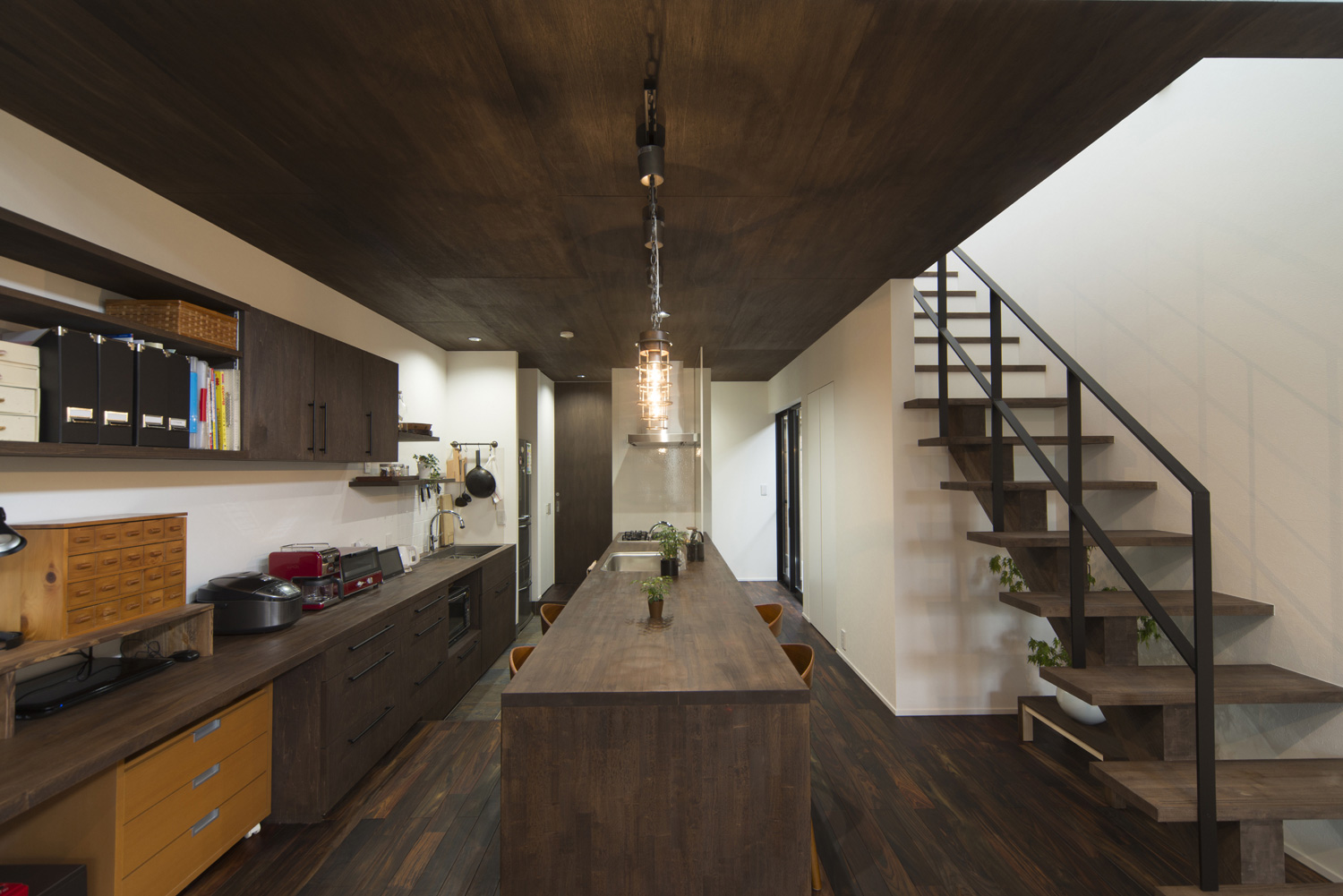 濃い色の木目の天井とした落ち着きのあるLDK・デザイン住宅