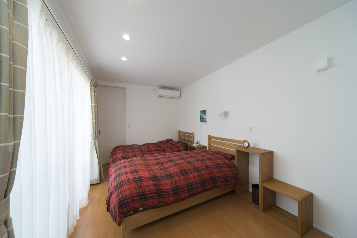 ベッドを二台並べた大きな窓があるシンプルな寝室・デザイン住宅