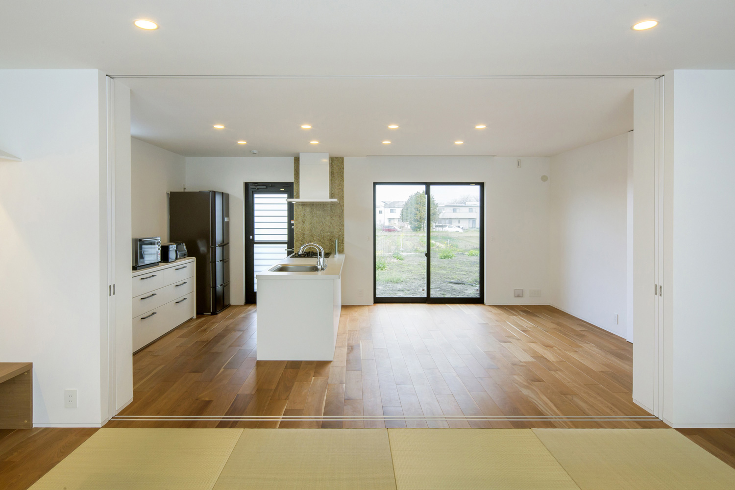 窓から外の景色が見えるフローリングのシンプルなLDKて