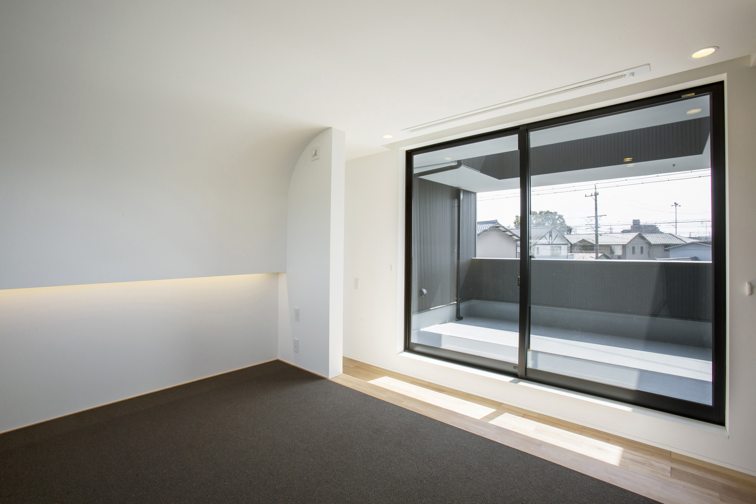 バルコニーに面した大きな窓がある開放的でおしゃれな寝室・デザイン住宅