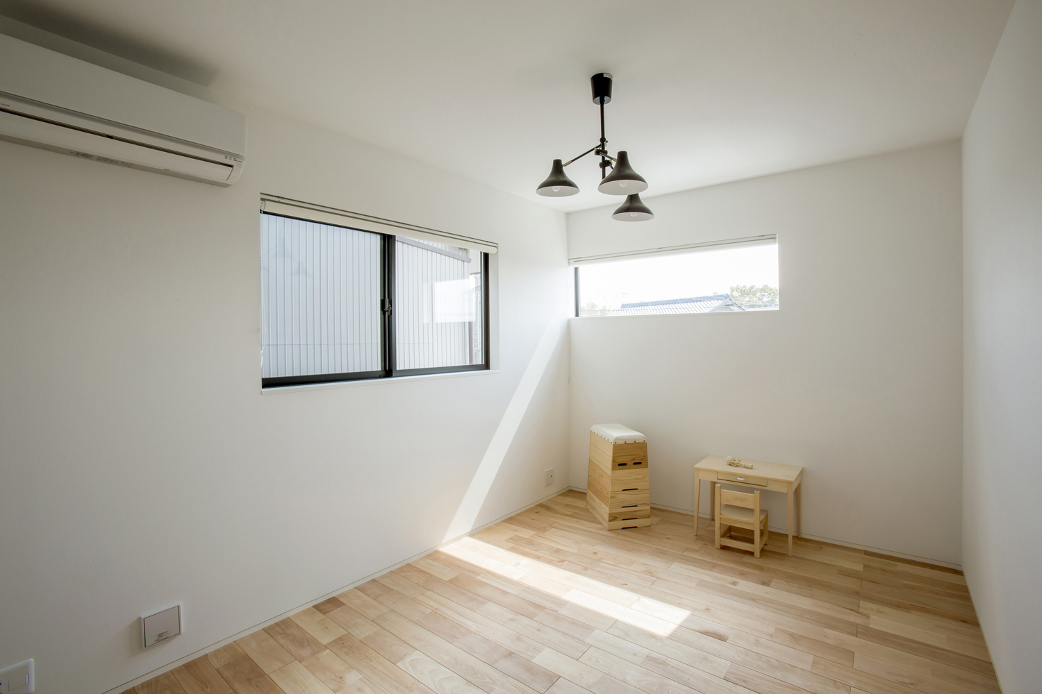 おしゃれなペンダントライトを取り付けたスリット窓のある寝室・デザイン住宅