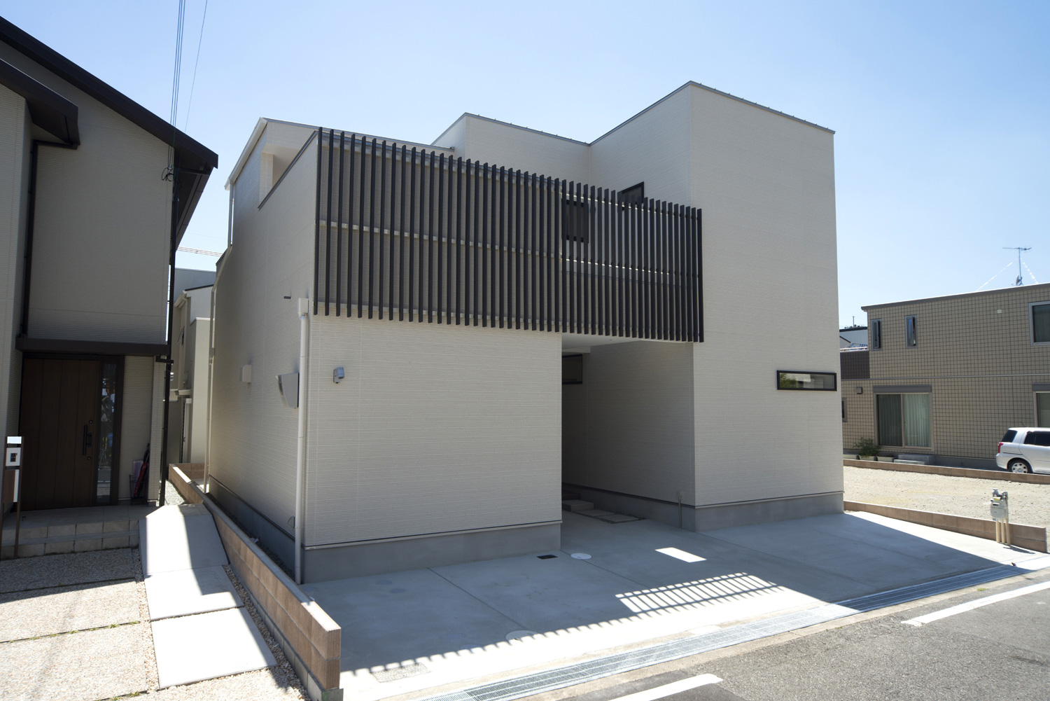 白い外壁に黒のルーバーを取り付けたモノトーンのシンプルな外観・デザイン住宅