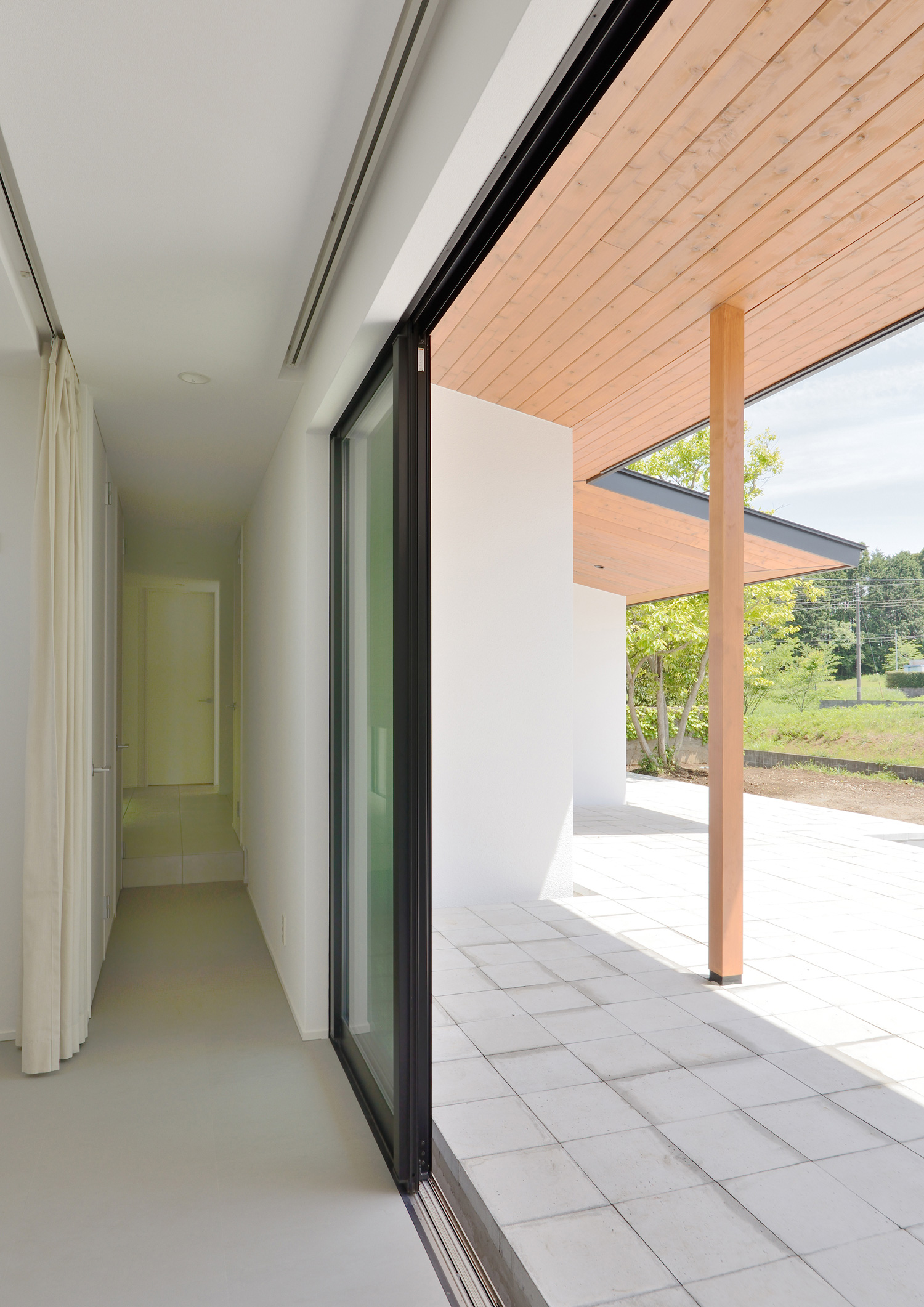 軒天井のあるテラスとフラットに繋がる開放的な廊下・デザイン住宅