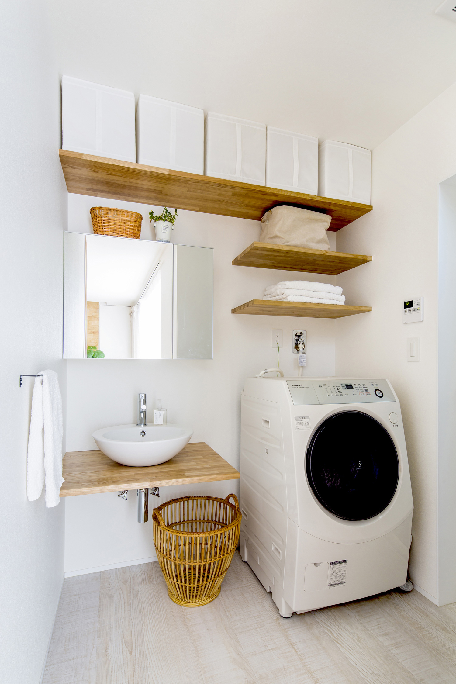 頭上に収納棚を取り付けたコンパクトでシンプルな洗面所・デザイン住宅