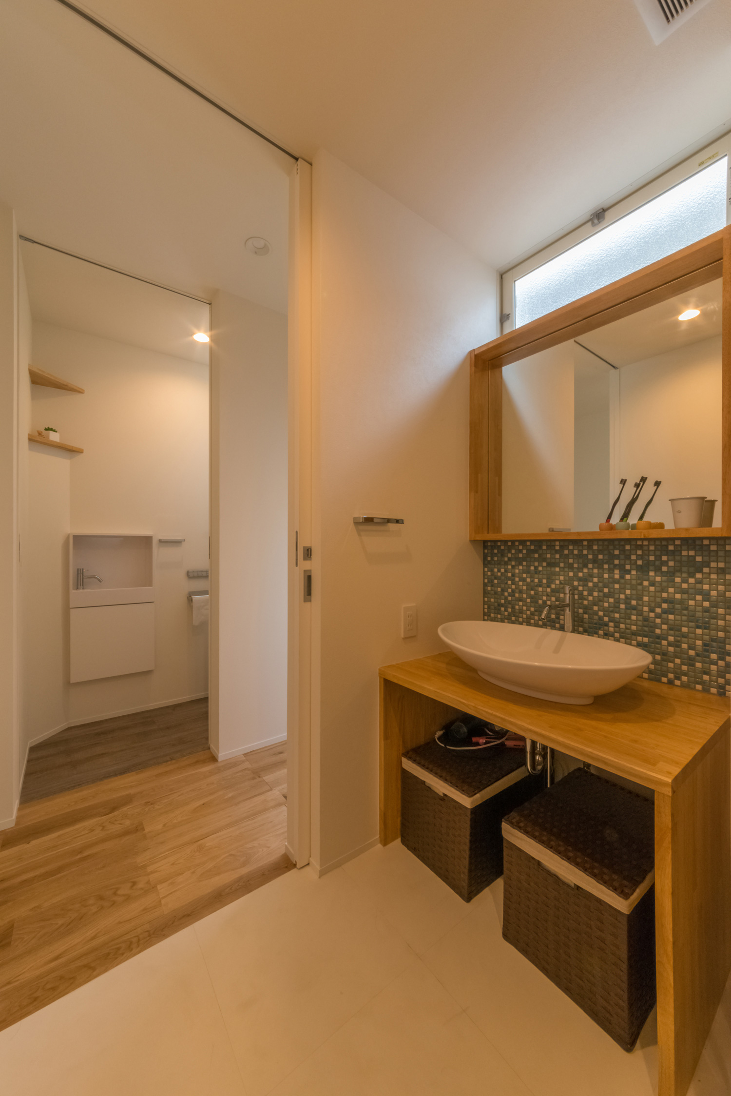 タイルの壁がアクセントになった木の洗面台がある洗面所・デザイン住宅 注文住宅・デザイン住宅建築実例_『CASE434 HIDAMARI』_浴室・洗面所
