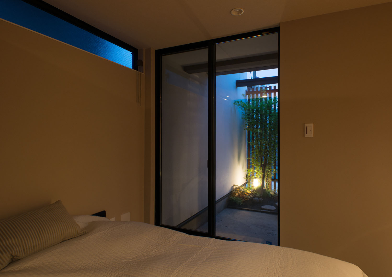 ライトアップされた植栽が窓から見える寝室・デザイン住宅 注文住宅・デザイン住宅建築実例_『CASE453 brun』_寝室