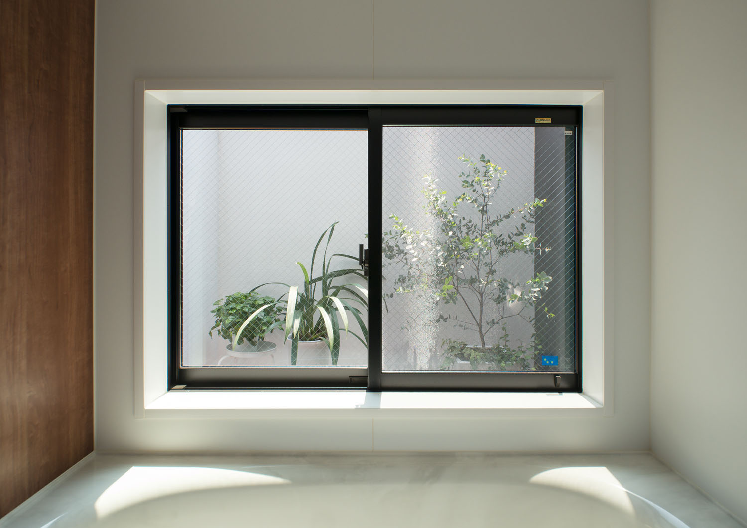 窓から植栽が見える木目の壁の浴室・デザイン住宅 注文住宅・デザイン住宅建築実例_『CASE453 brun』_浴室・洗面所