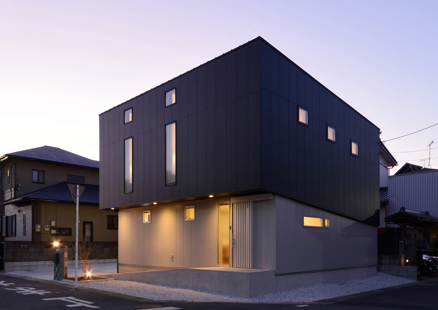 間接照明に照らされるモノトーンの外観の家を斜めから見た様子・デザイン住宅 注文住宅・デザイン住宅建築実例_『CASE463 Individual Contrast』_外観