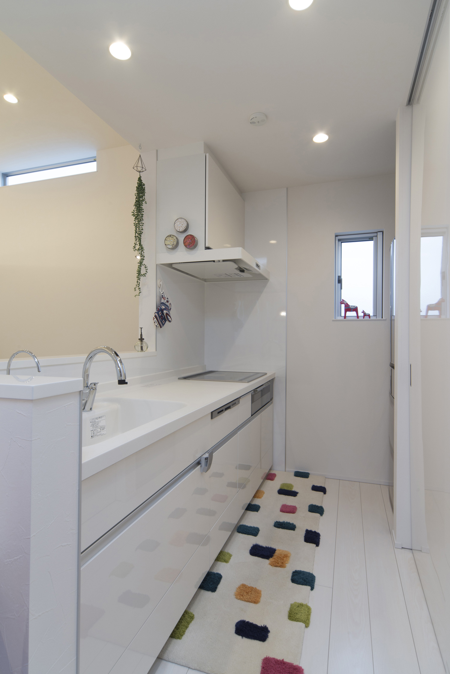 コンロの前に壁がある白いペニンシュラキッチン・デザイン住宅 注文住宅・デザイン住宅建築実例_『CASE466 片流れの家』_キッチン