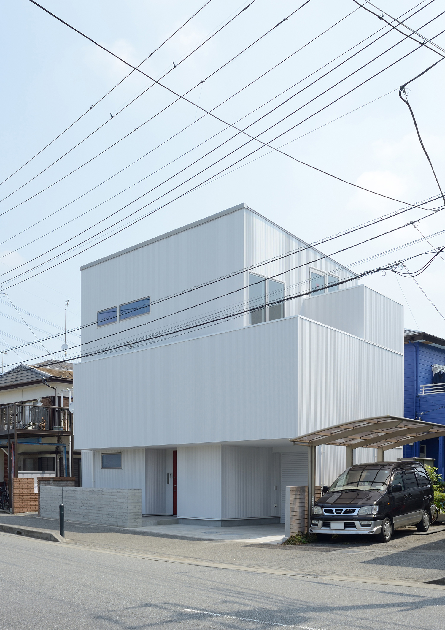 白いシンプルな外壁の住まいを斜めから見た様子・デザイン住宅 注文住宅・デザイン住宅建築実例_『CASE498 シロイイエ』_外観