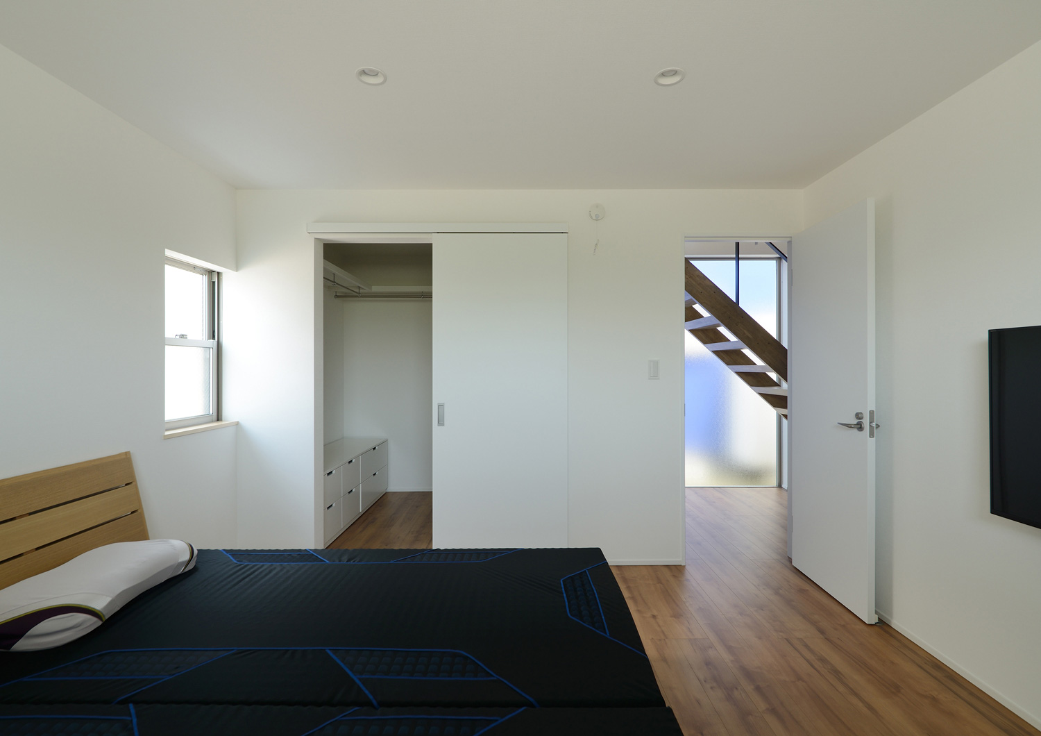 扉付きのウォークインクローゼットがある寝室・デザイン住宅 注文住宅・デザイン住宅建築実例_『CASE498 シロイイエ』_寝室