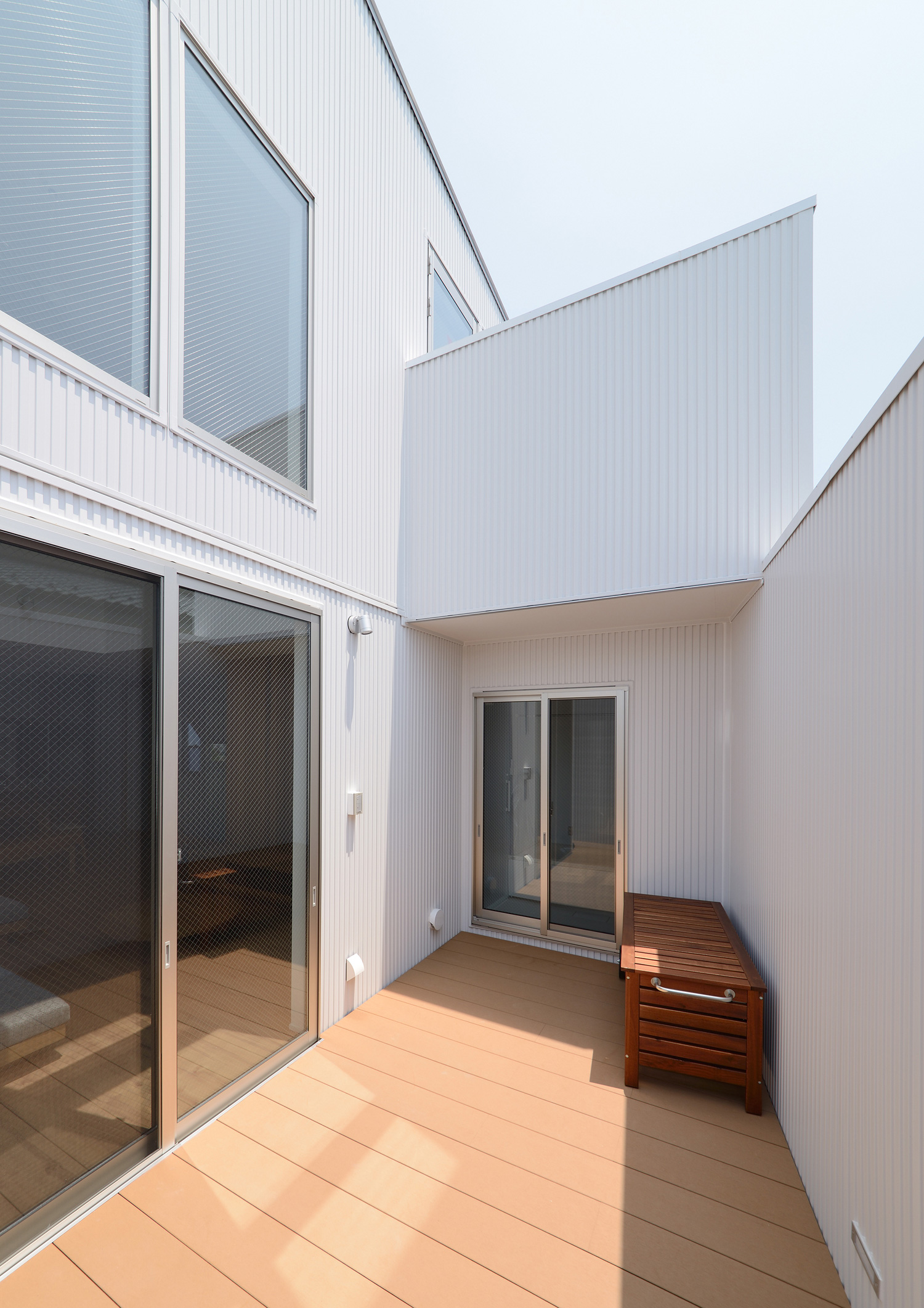 白い目隠し壁を取り付けたウッドデッキのテラス・デザイン住宅 注文住宅・デザイン住宅建築実例_『CASE498 シロイイエ』_テラス・バルコニー