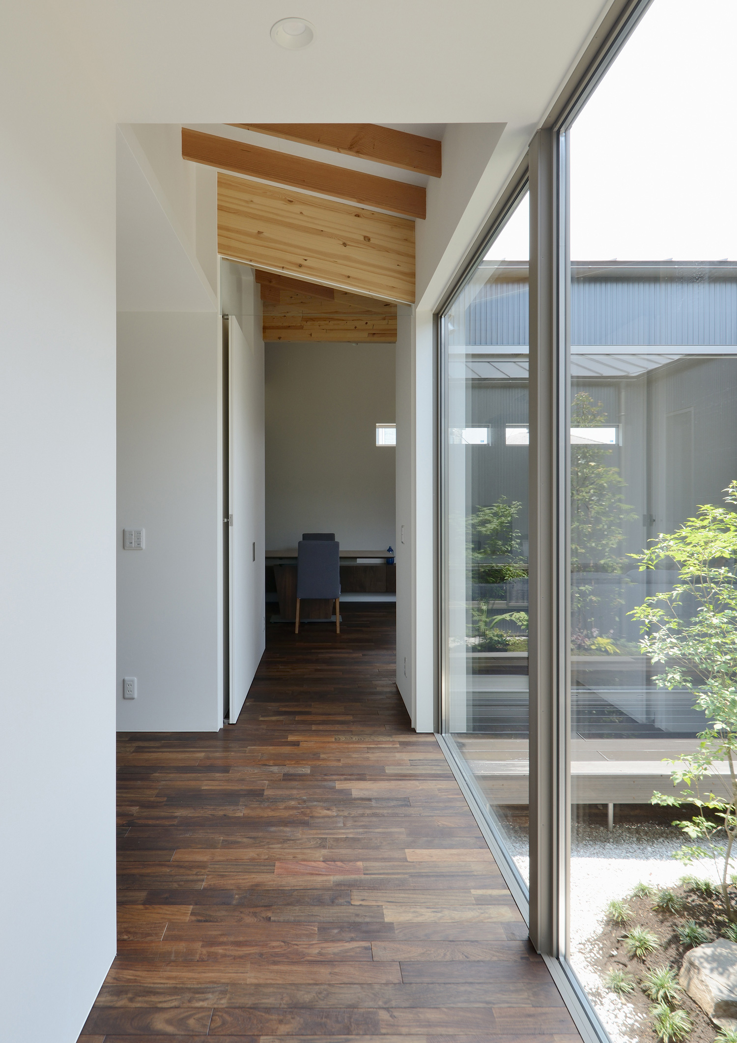 中庭に面した大開口窓があるウォルナットのフローリングの廊下・デザイン住宅 注文住宅・デザイン住宅建築実例_『CASE508 Slither Link』_廊下