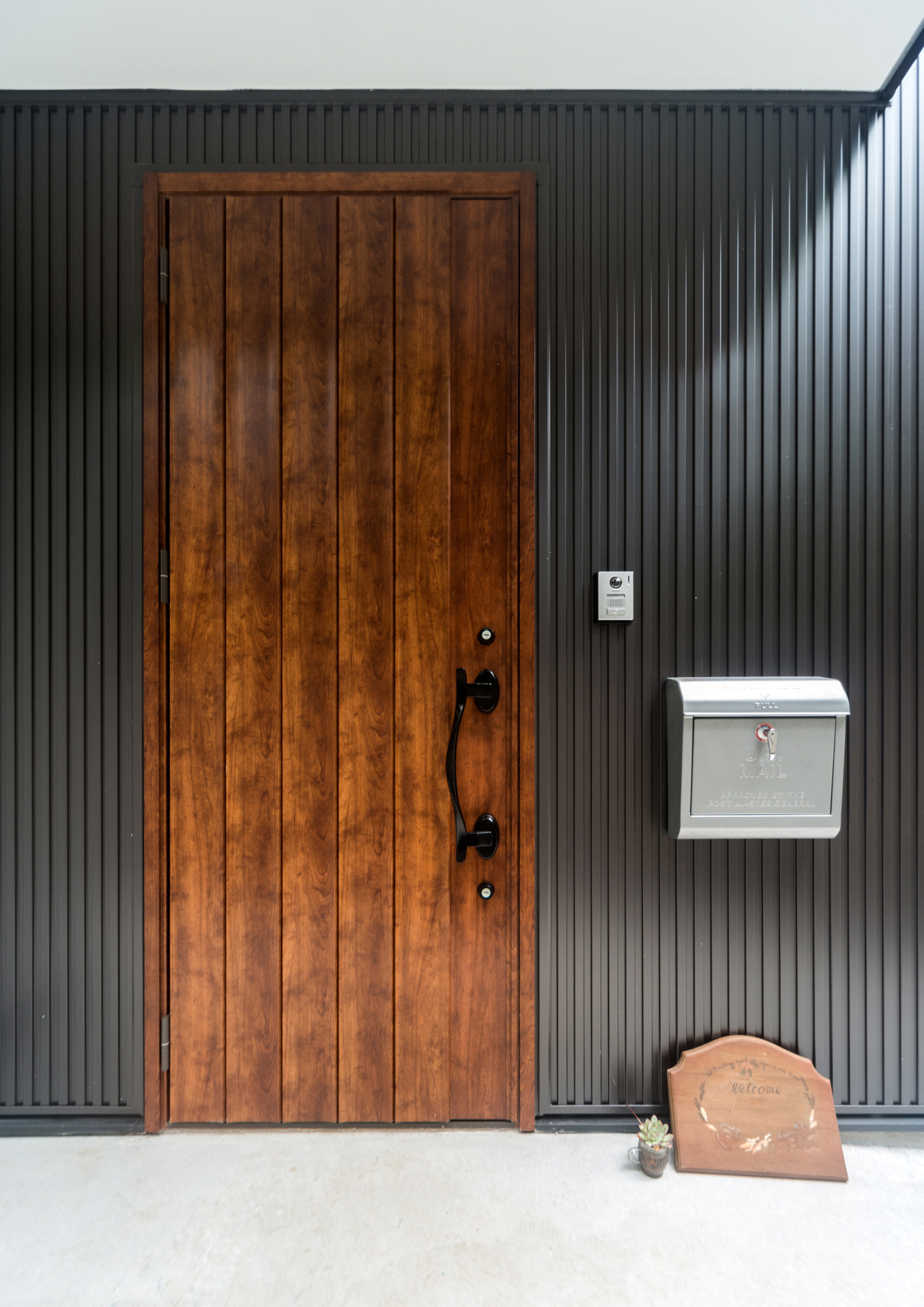 黒い外壁に木の玄関扉が取り付けられた落ち着きのある外観・デザイン住宅 注文住宅・デザイン住宅建築実例_『CASE513 踊るハウス』_外観