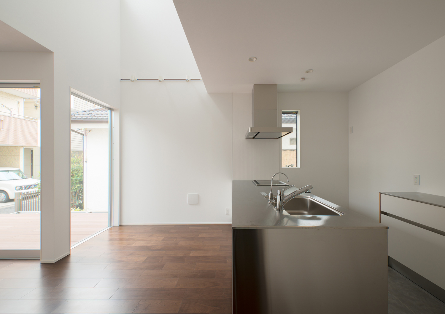 ステンレスのシンプルなキッチンがある吹き抜けのLDK・デザイン住宅 注文住宅・デザイン住宅建築実例_『CASE522 LAYER – HOUSE』_LDK