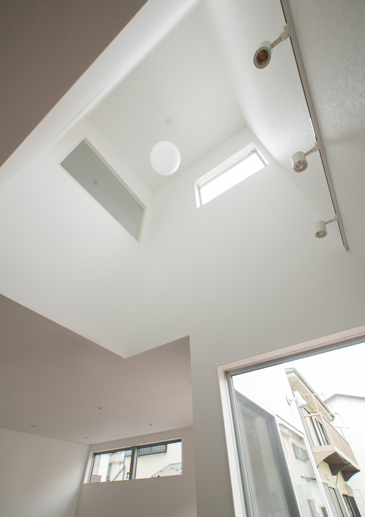 窓を設けた吹き抜けがある白い壁のLDK・デザイン住宅 注文住宅・デザイン住宅建築実例_『CASE522 LAYER – HOUSE』_LDK