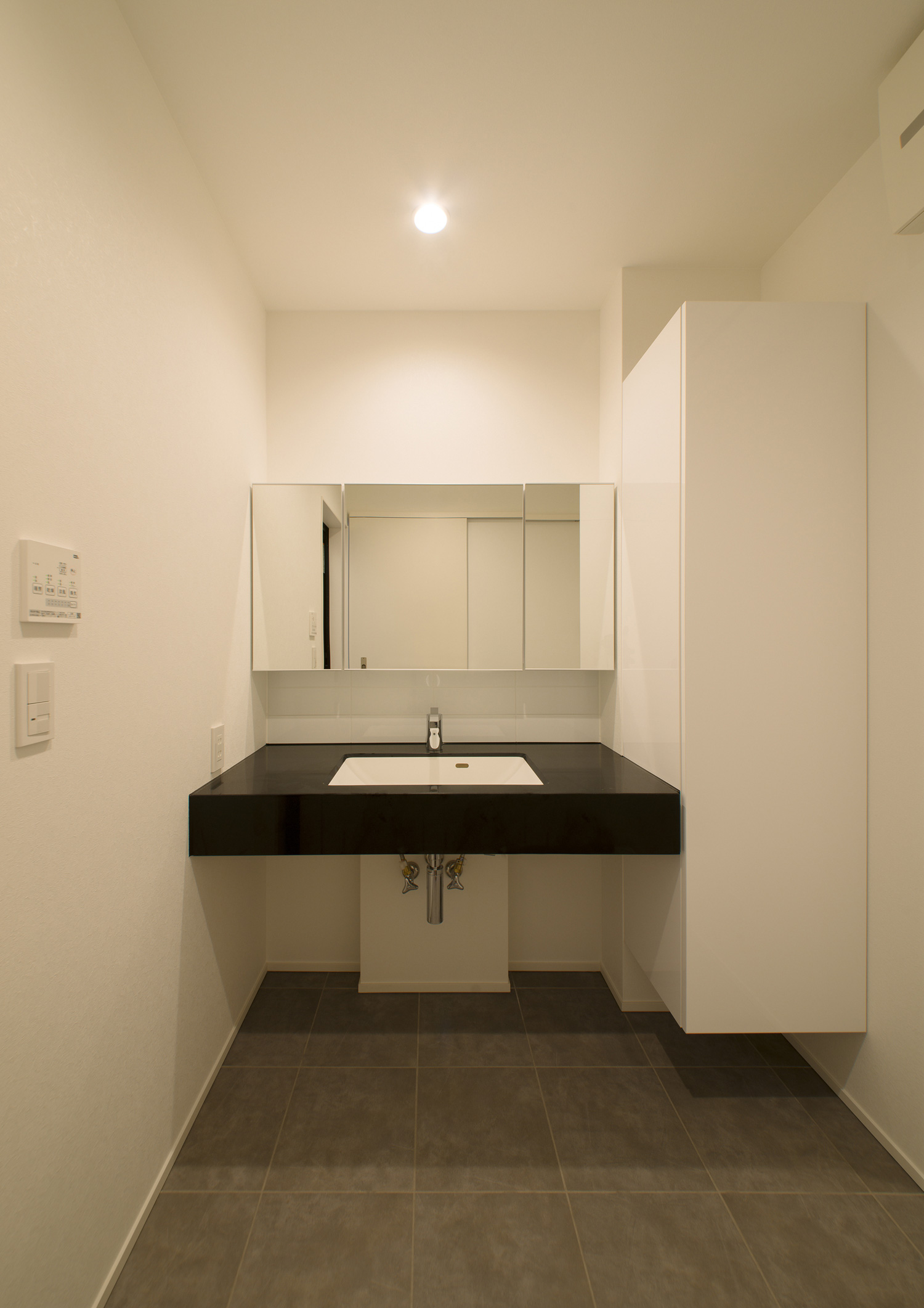 黒い洗面台を設けたシンプルなモノトーンの洗面所・デザイン住宅 注文住宅・デザイン住宅建築実例_『CASE522 LAYER – HOUSE』_浴室・洗面所