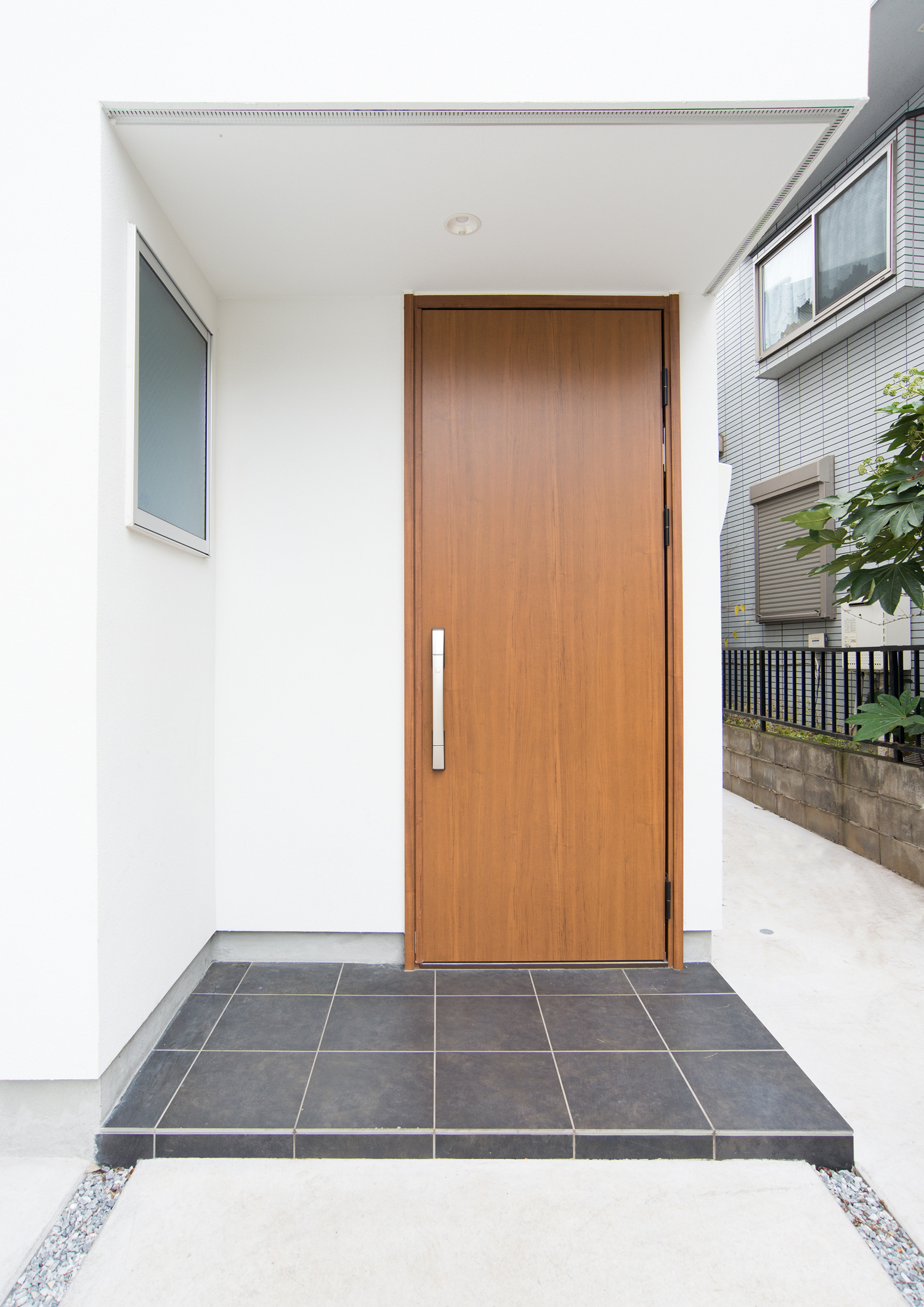 木製の玄関扉を取り付けたタイルの玄関ポーチ・デザイン住宅 注文住宅・デザイン住宅建築実例_『CASE523 くのじのいえ』_外観