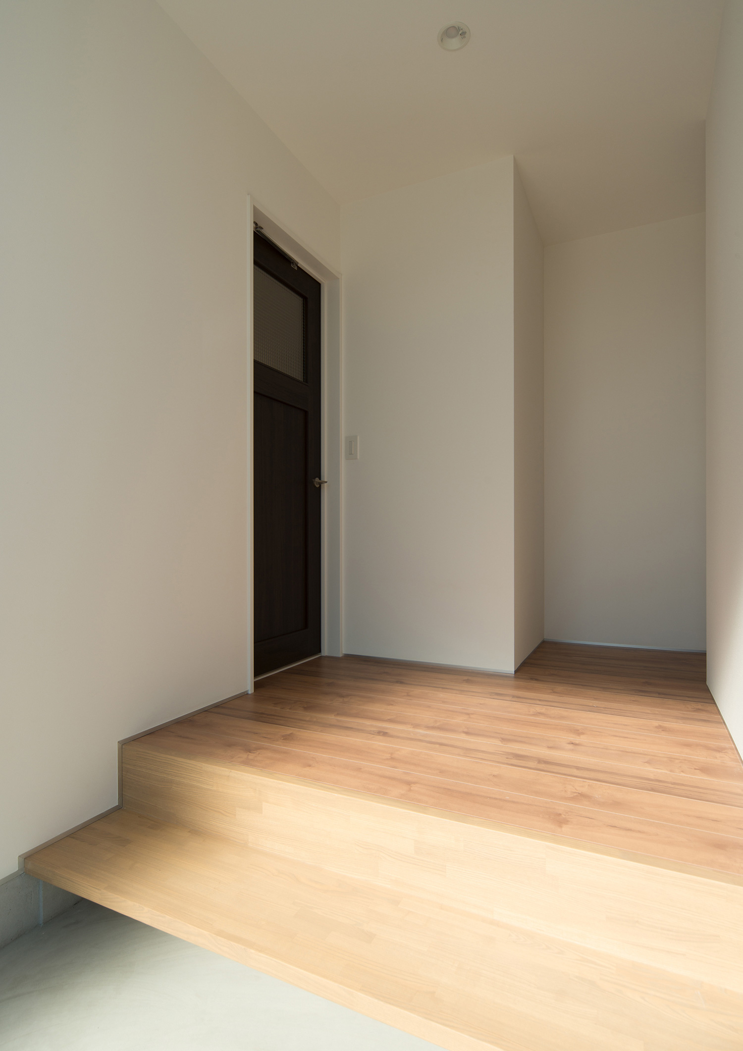 モルタルの玄関から繋がるフローリングの廊下・デザイン住宅 注文住宅・デザイン住宅建築実例_『CASE526 Two-tone』_玄関