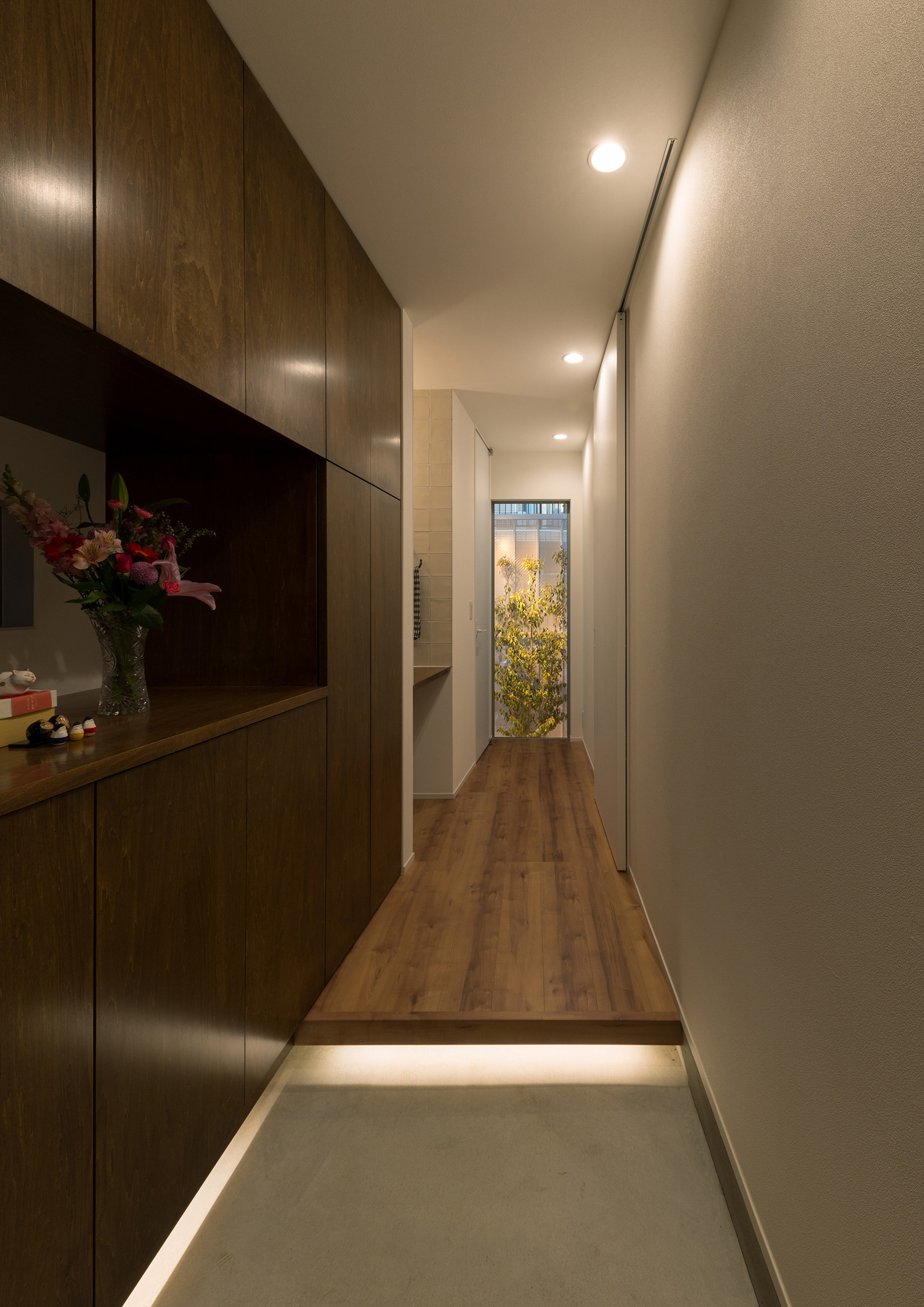 足元に間接照明を取り付けた、突き当たりに窓がある玄関・デザイン住宅 注文住宅・デザイン住宅建築実例_『CASE546 ウォールナットとガラスの家』_玄関