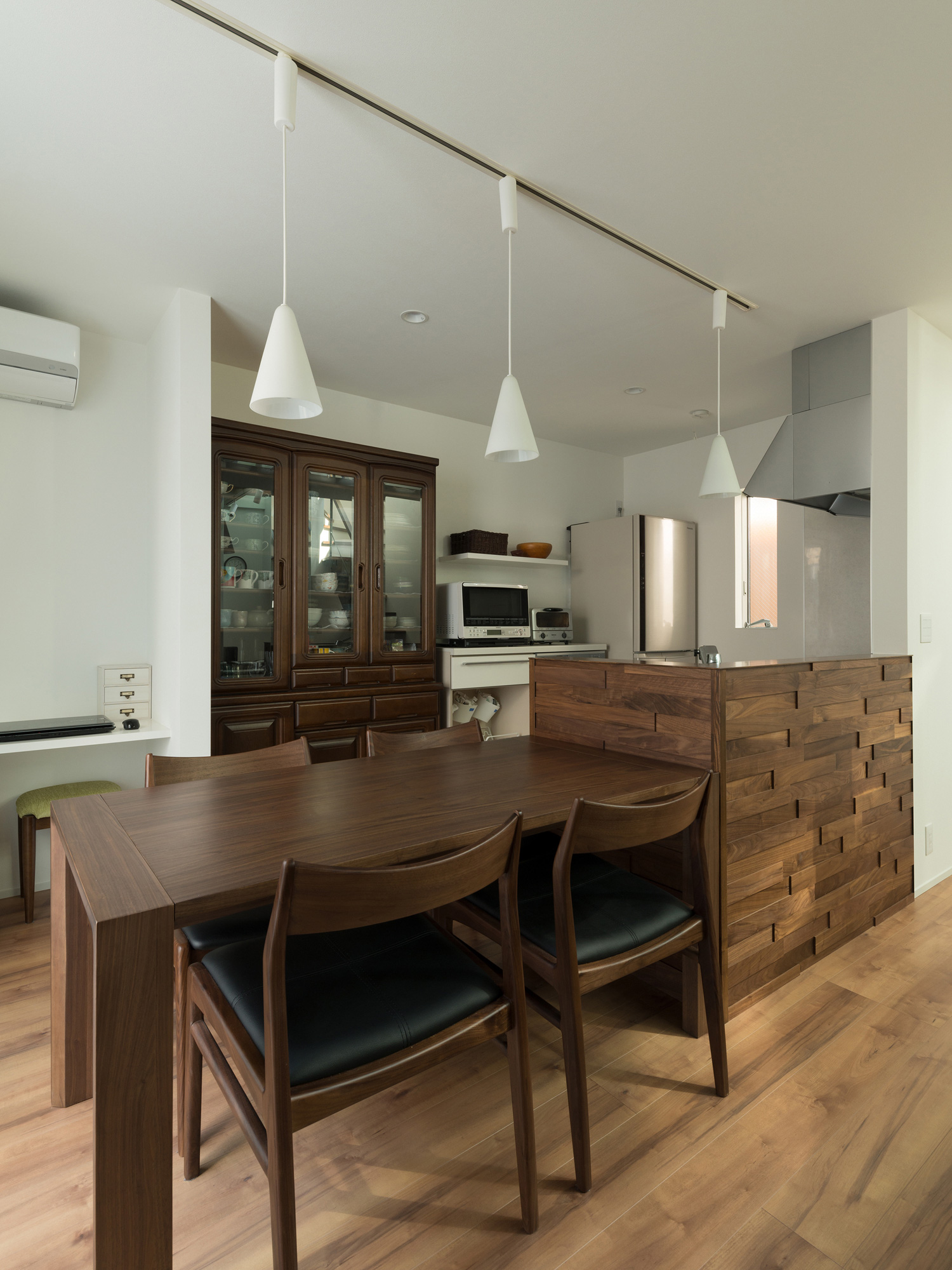 ペンダントライトに照らされた木のキッチンのダイニングテーブル・デザイン住宅 注文住宅・デザイン住宅建築実例_『CASE546 ウォールナットとガラスの家』_LDK