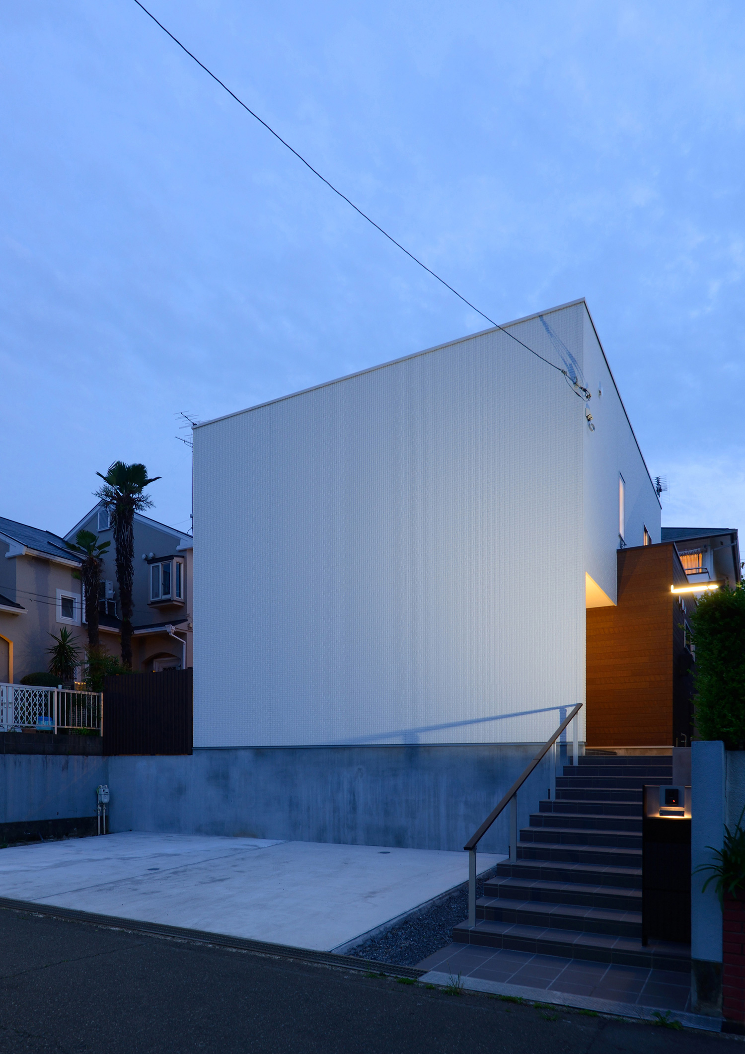 コンクリートの駐車スペースと階段アプローチの先にある白い外壁の家・デザイン住宅 注文住宅・デザイン住宅建築実例_『CASE561 TOHFU-HOUSE』_外観