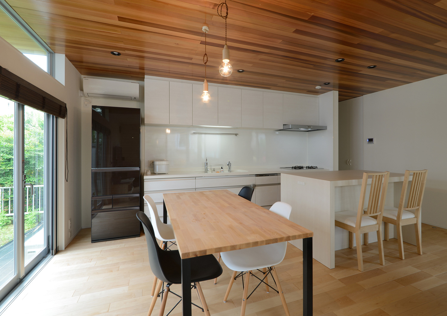 木のダイニングテーブルとキッチンの向かい側にカウンターを設けた木目の天井のLDK・デザイン住宅 注文住宅・デザイン住宅建築実例_『CASE561 TOHFU-HOUSE』_LDK