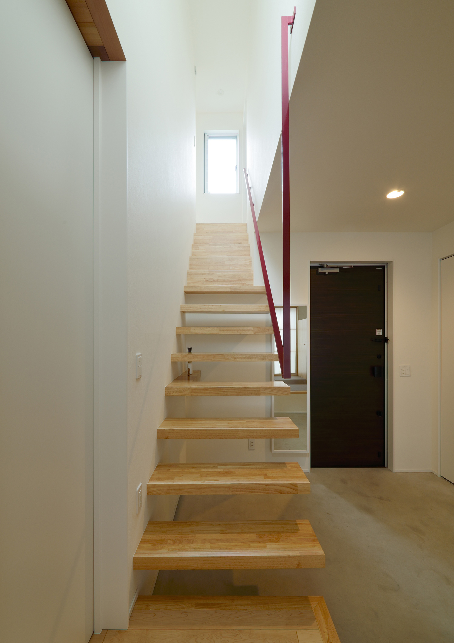 モルタルの玄関を横切る木製のスケルトン階段・デザイン住宅 注文住宅・デザイン住宅建築実例_『CASE561 TOHFU-HOUSE』_階段