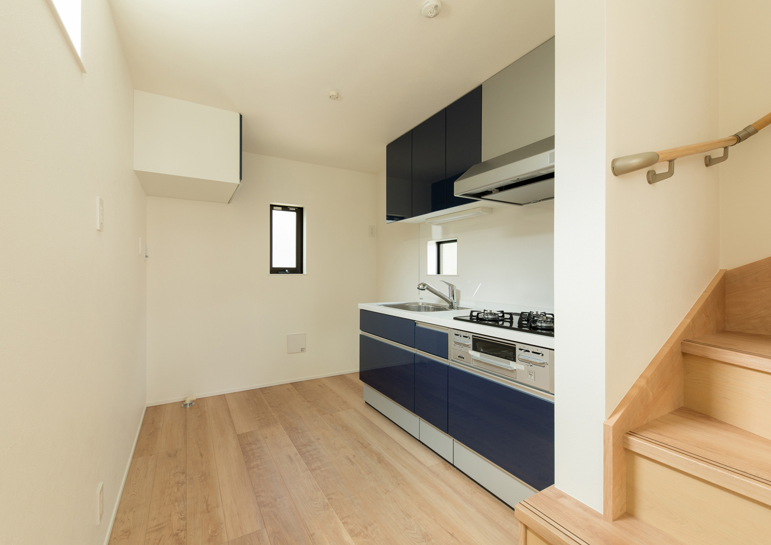 フローリングのフロアにある青い壁付きキッチン・デザイン住宅 注文住宅・デザイン住宅建築実例_『CASE562 タテ長い家』_LDK