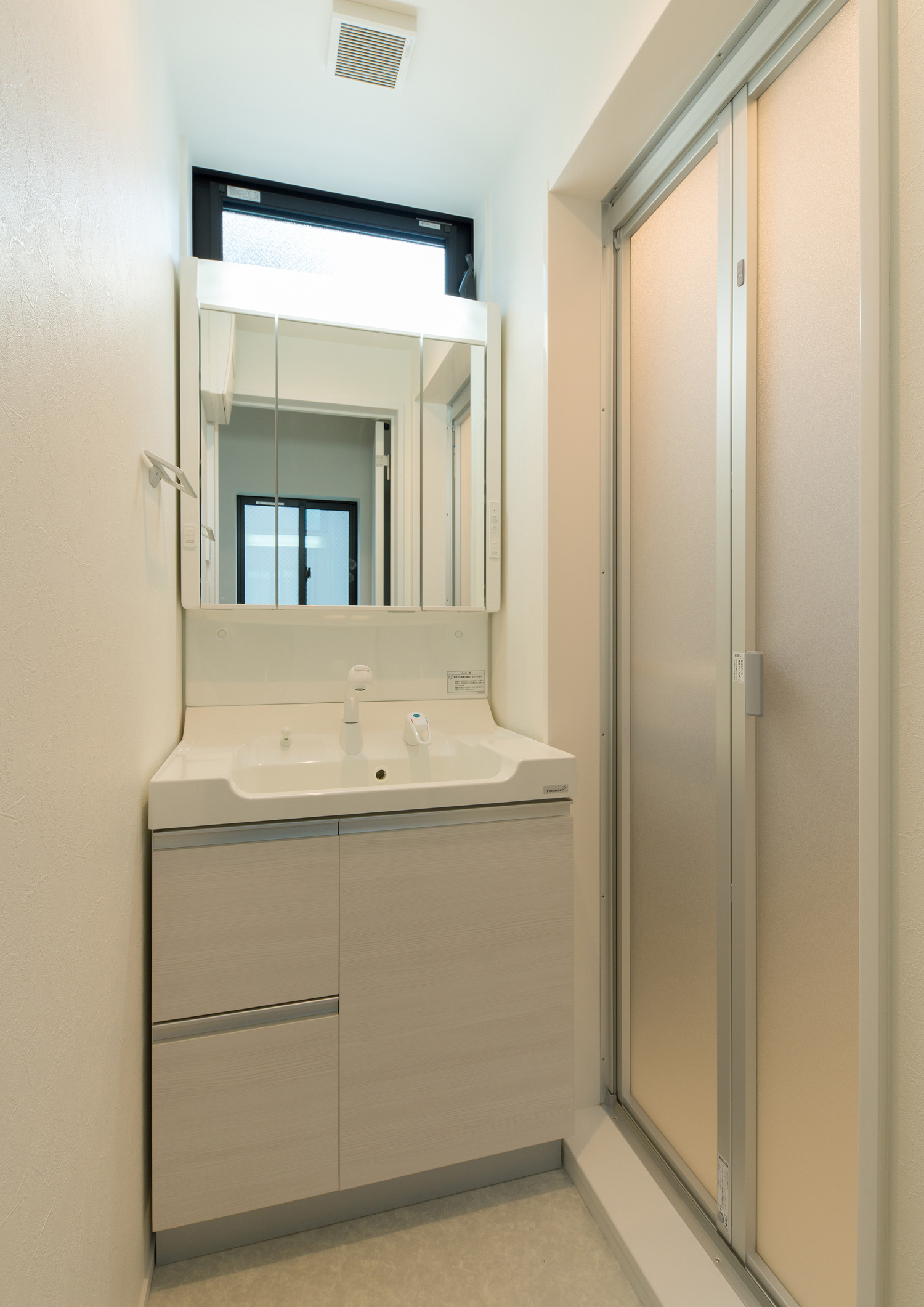浴室の隣にあるミラーキャビネット付きの洗面所・デザイン住宅 注文住宅・デザイン住宅建築実例_『CASE562 タテ長い家』_浴室・洗面所