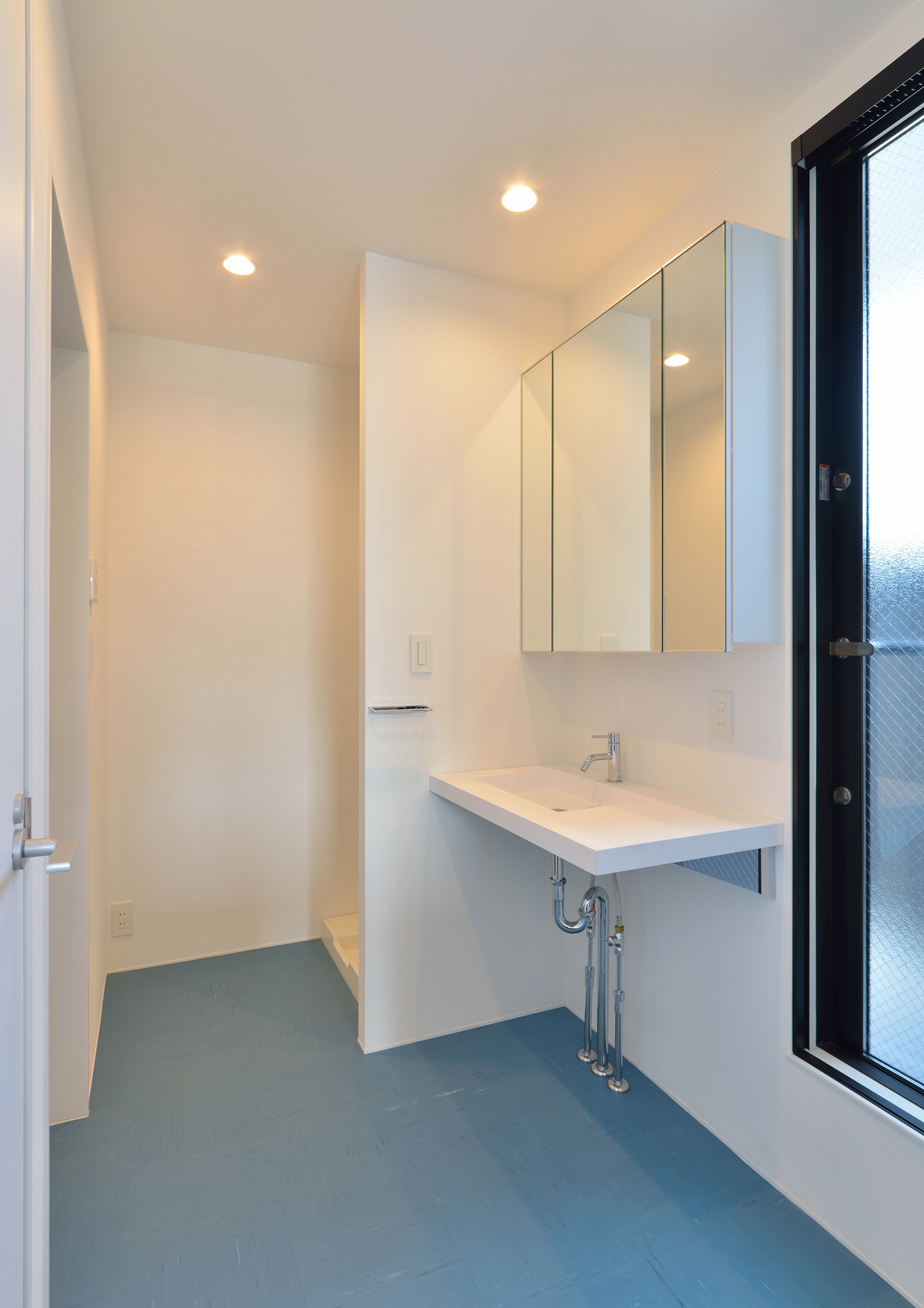 水色の床で白いインテリアのおしゃれな洗面所・デザイン住宅 注文住宅・デザイン住宅建築実例_『CASE566 拡がりを内包する黒庭』_浴室・洗面所