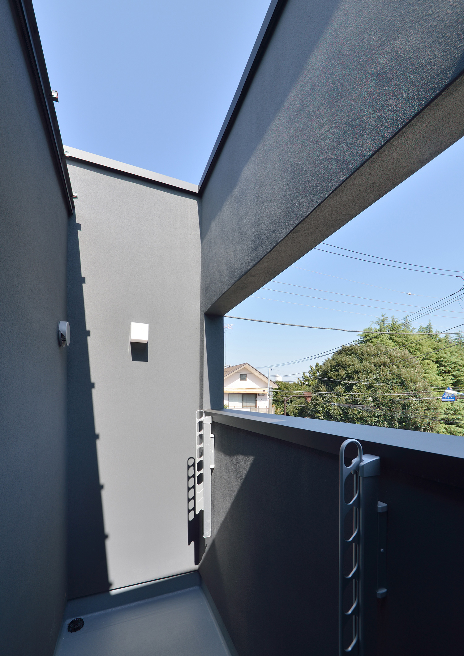 物干し金具がある、黒い壁に囲まれたプライバシー性の高いバルコニー・デザイン住宅 注文住宅・デザイン住宅建築実例_『CASE566 拡がりを内包する黒庭』_テラス・バルコニー