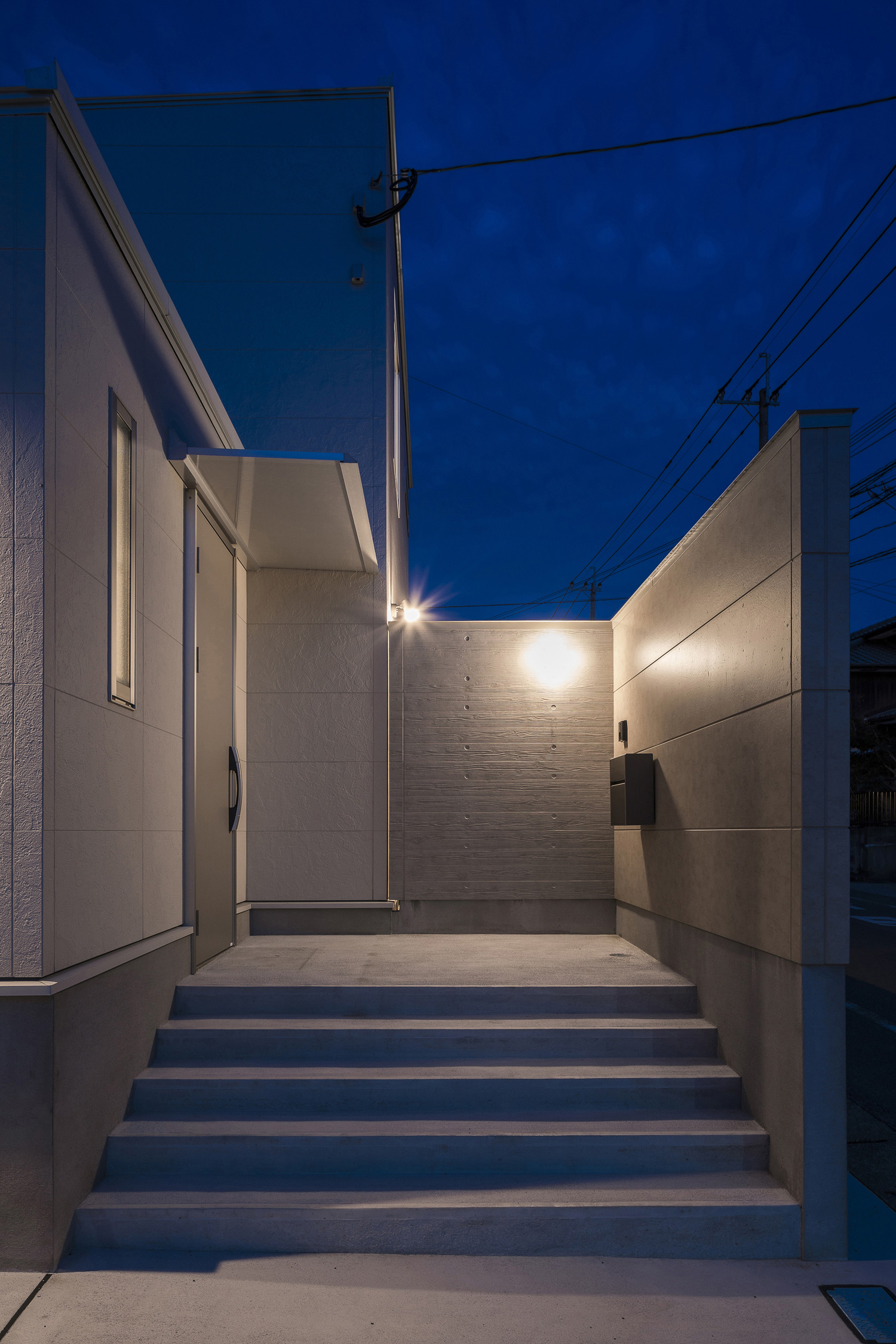 目隠し壁に取り付けられた照明に照らされる階段の玄関アプローチ・デザイン住宅 注文住宅・デザイン住宅建築実例_『CASE567 lokki』_外観