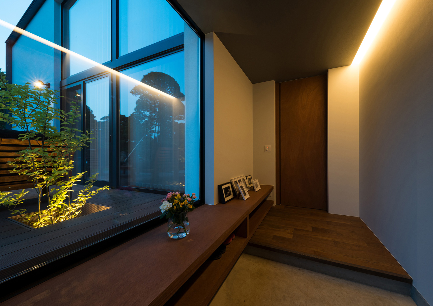 壁際にライン照明を取り付けたテラスに面した玄関・デザイン住宅 注文住宅・デザイン住宅建築実例_『CASE573 次代の家』_玄関