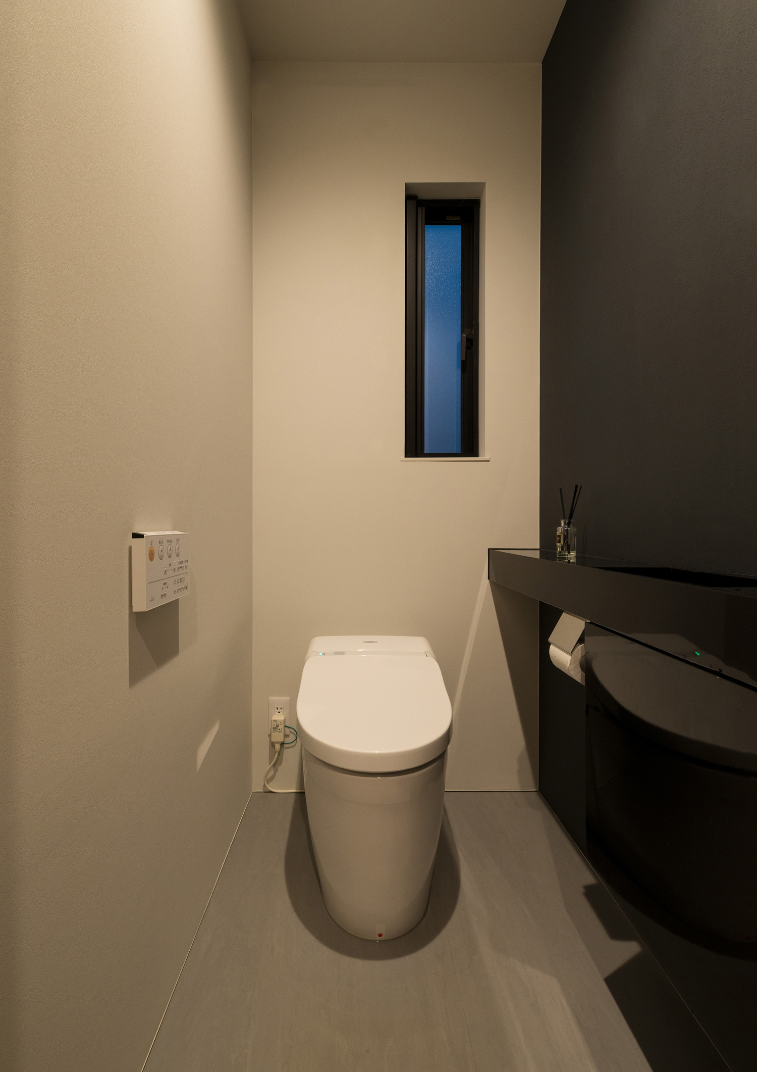 縦長のスリット窓がある黒いアクセントクロスを設けたトイレ・デザイン住宅 注文住宅・デザイン住宅建築実例_『CASE573 次代の家』_トイレ