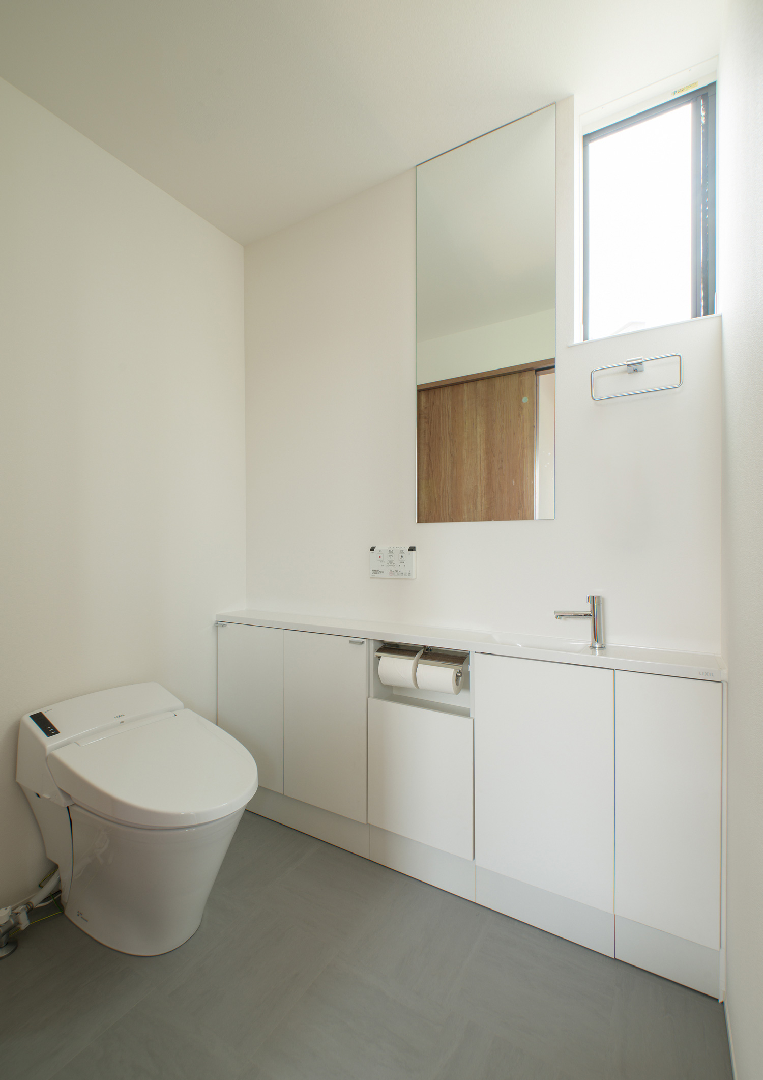 手洗いカウンターの下に収納を設けた白で統一されたトイレ・デザイン住宅 注文住宅・デザイン住宅建築実例_『CASE575 緑を楽しむ家』_トイレ
