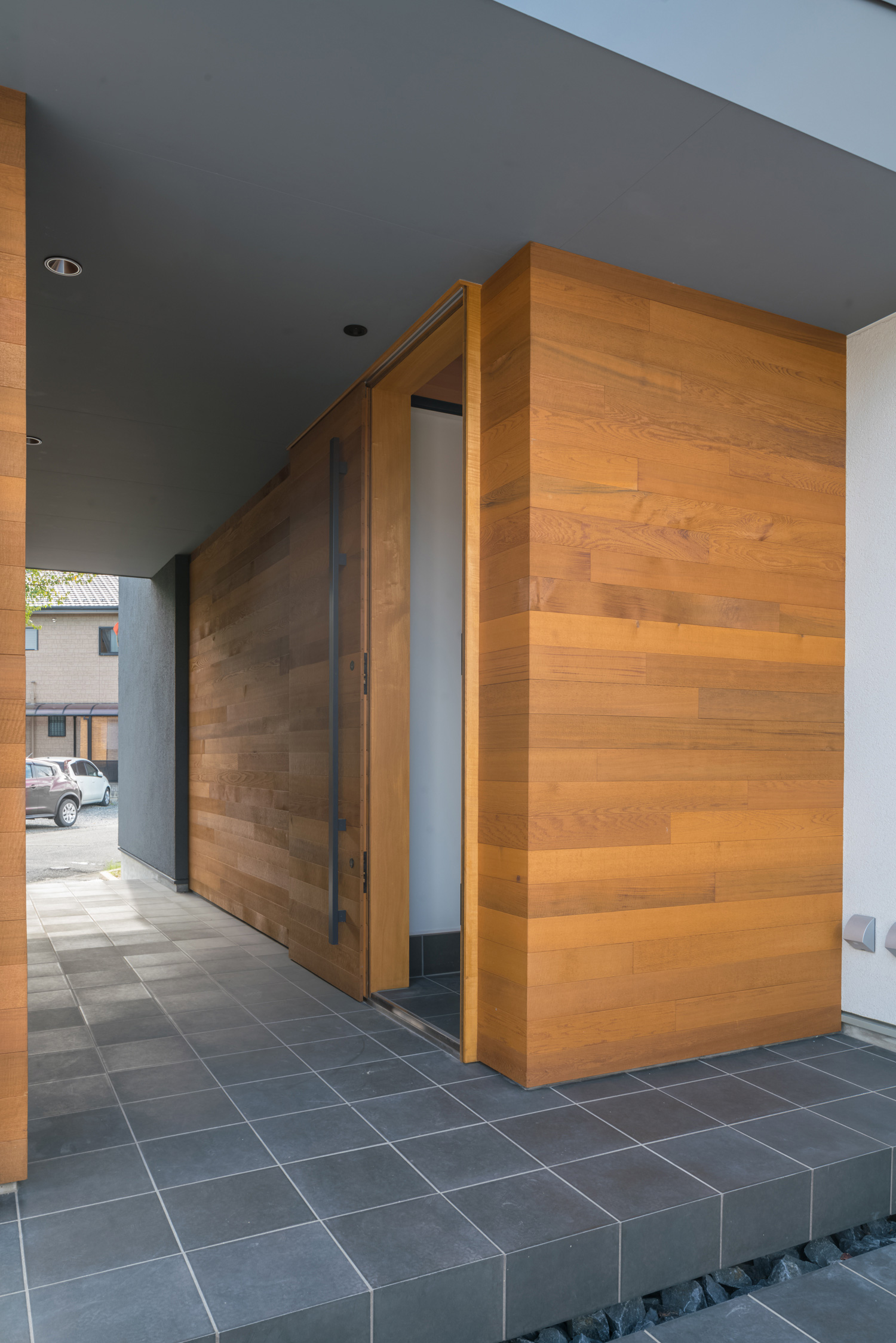 玄関扉と壁に同じ木材を使用した玄関アプローチ・デザイン住宅 注文住宅・デザイン住宅建築実例_『CASE576 回廊の家』_外観