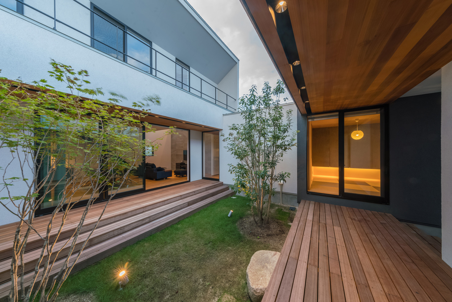 ウッドデッキ付きの芝生の中庭を囲んで部屋があるデザイン・デザイン住宅 注文住宅・デザイン住宅建築実例_『CASE576 回廊の家』_中庭