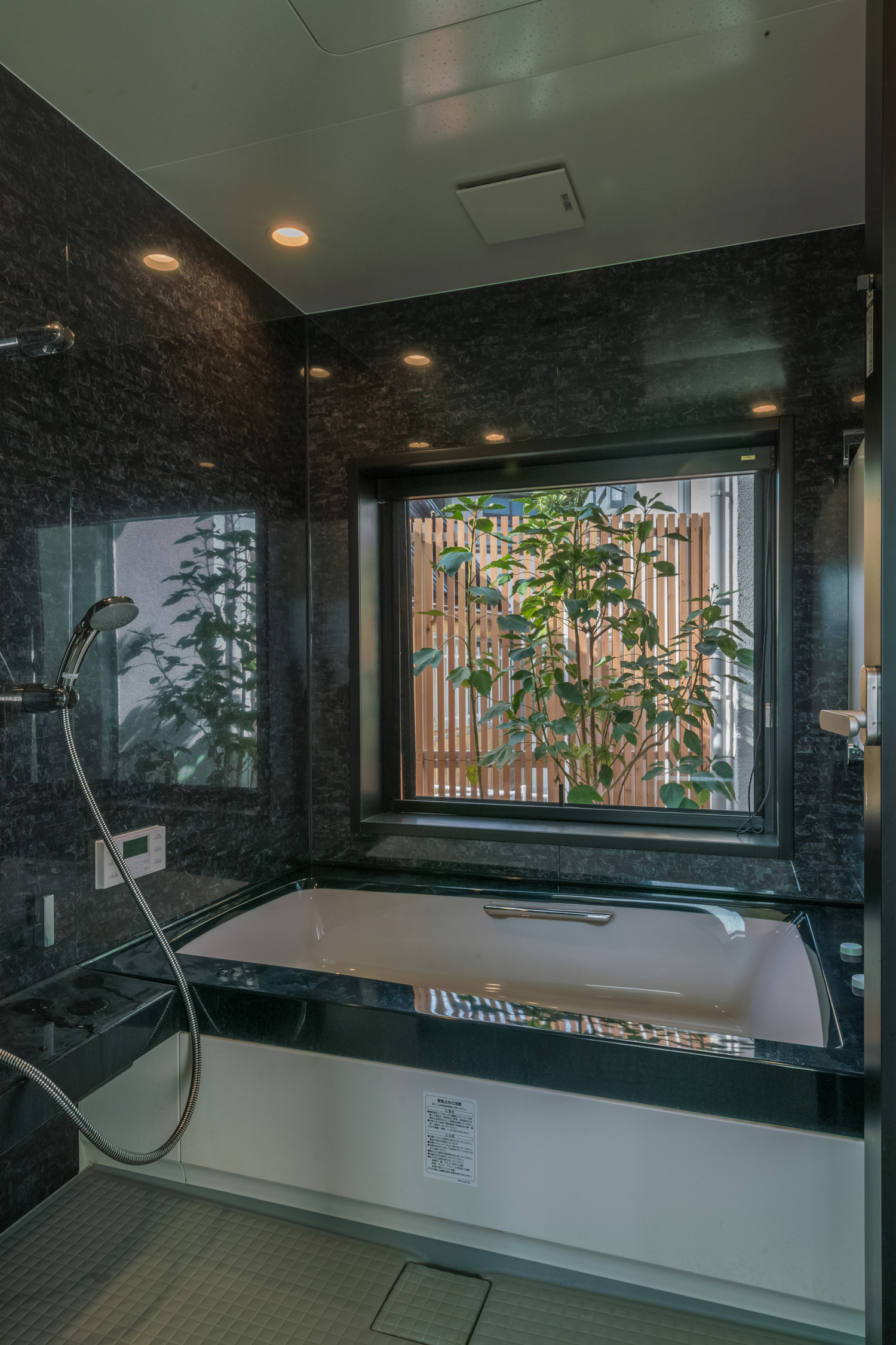 植栽の見える窓がある黒い壁の浴室・デザイン住宅 注文住宅・デザイン住宅建築実例_『CASE576 回廊の家』_浴室・洗面所