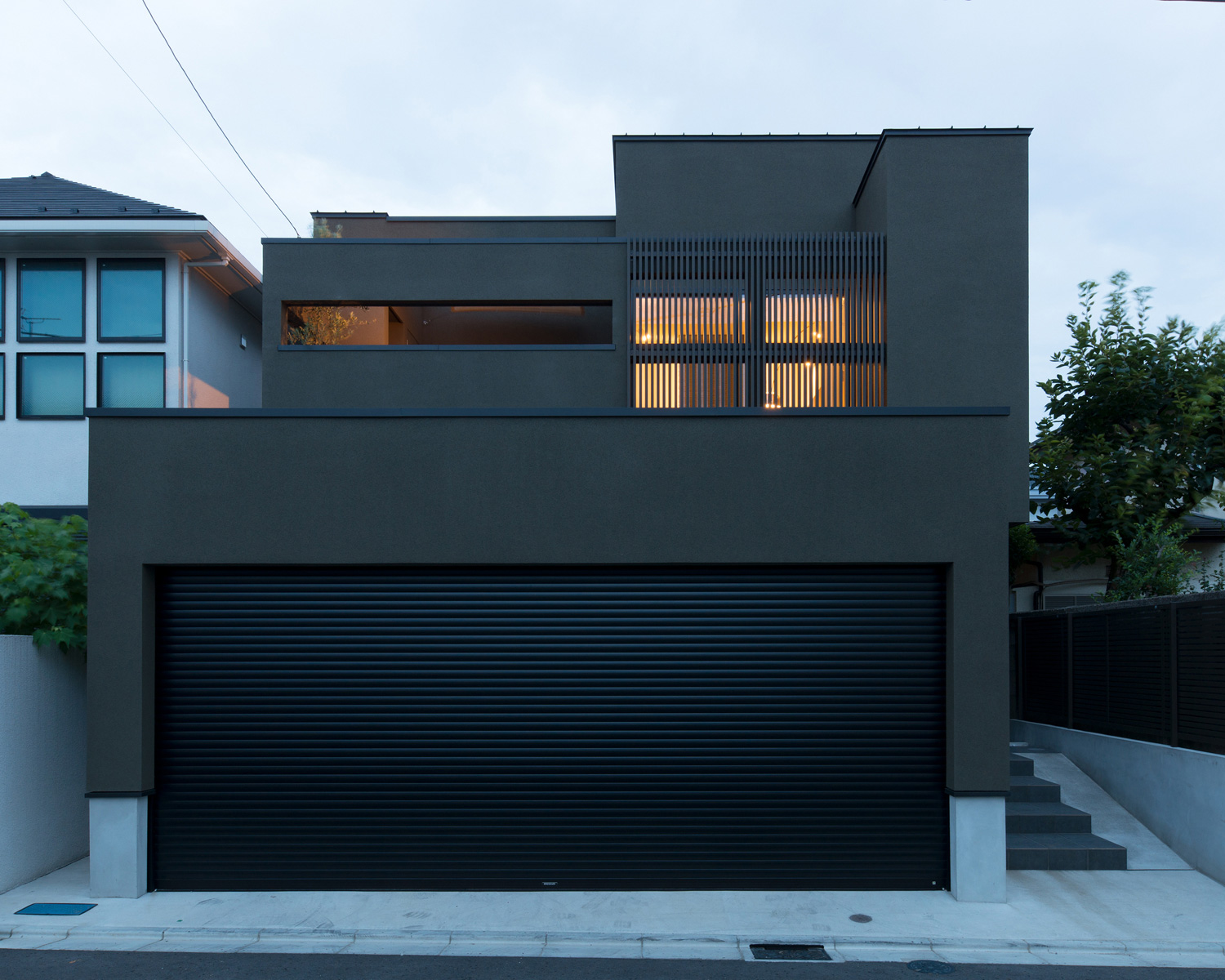 二階のベランダのルーバーの目隠しから光が漏れる外観・デザイン住宅 注文住宅・デザイン住宅建築実例_『CASE577 紬(つむぎ)の家』_外観