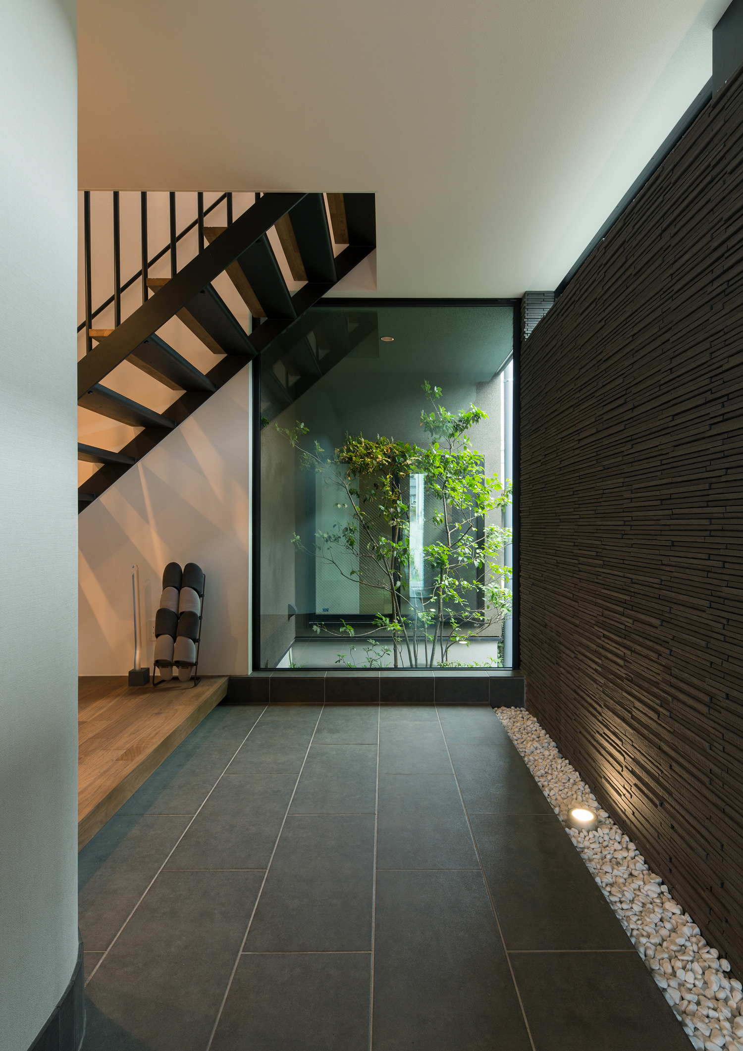 正面に植栽が見える窓があるタイルの玄関・デザイン住宅 注文住宅・デザイン住宅建築実例_『CASE577 紬(つむぎ)の家』_玄関