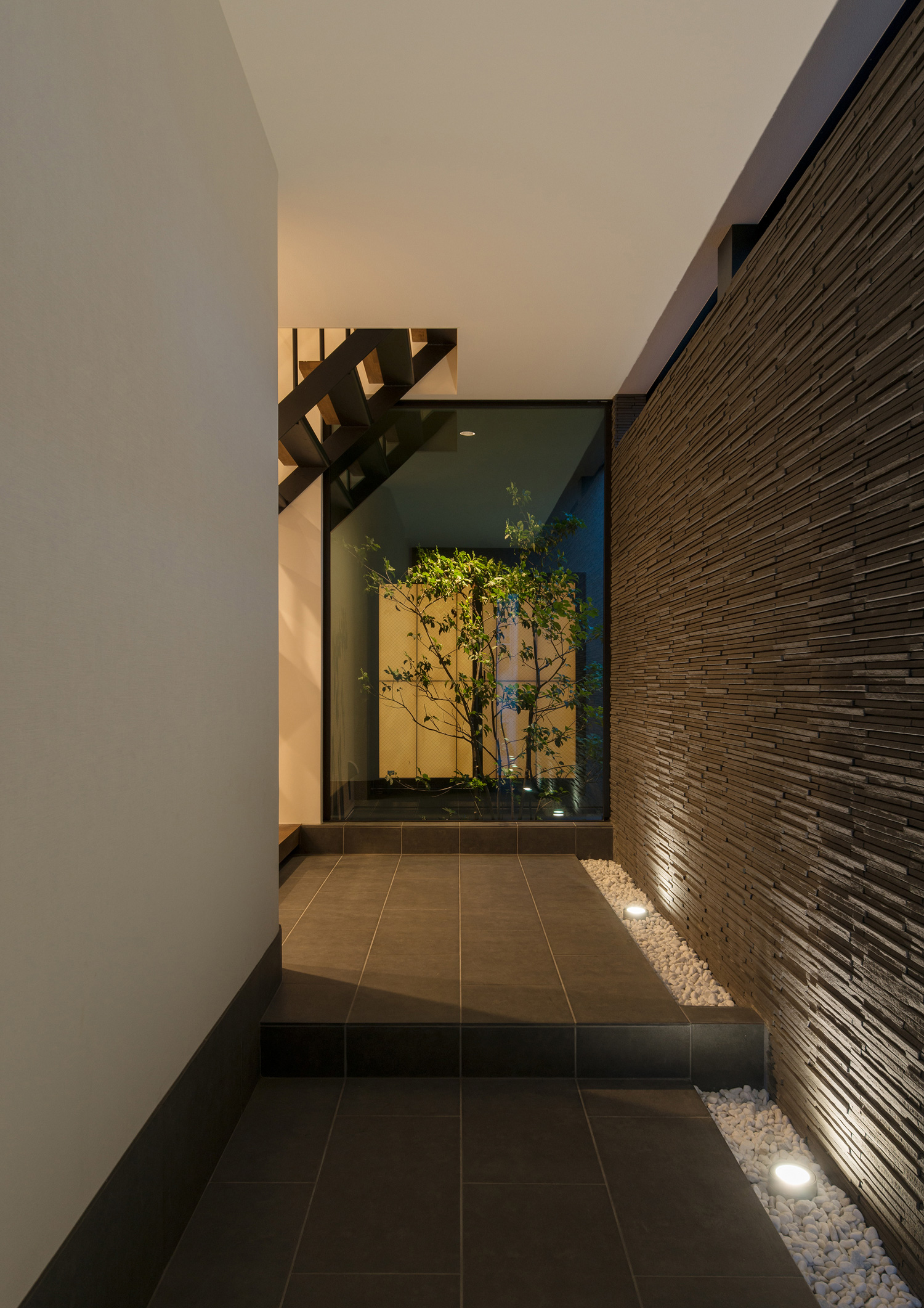 壁際の敷石に照明を取り付けて壁を照らした玄関・デザイン住宅 注文住宅・デザイン住宅建築実例_『CASE577 紬(つむぎ)の家』_玄関