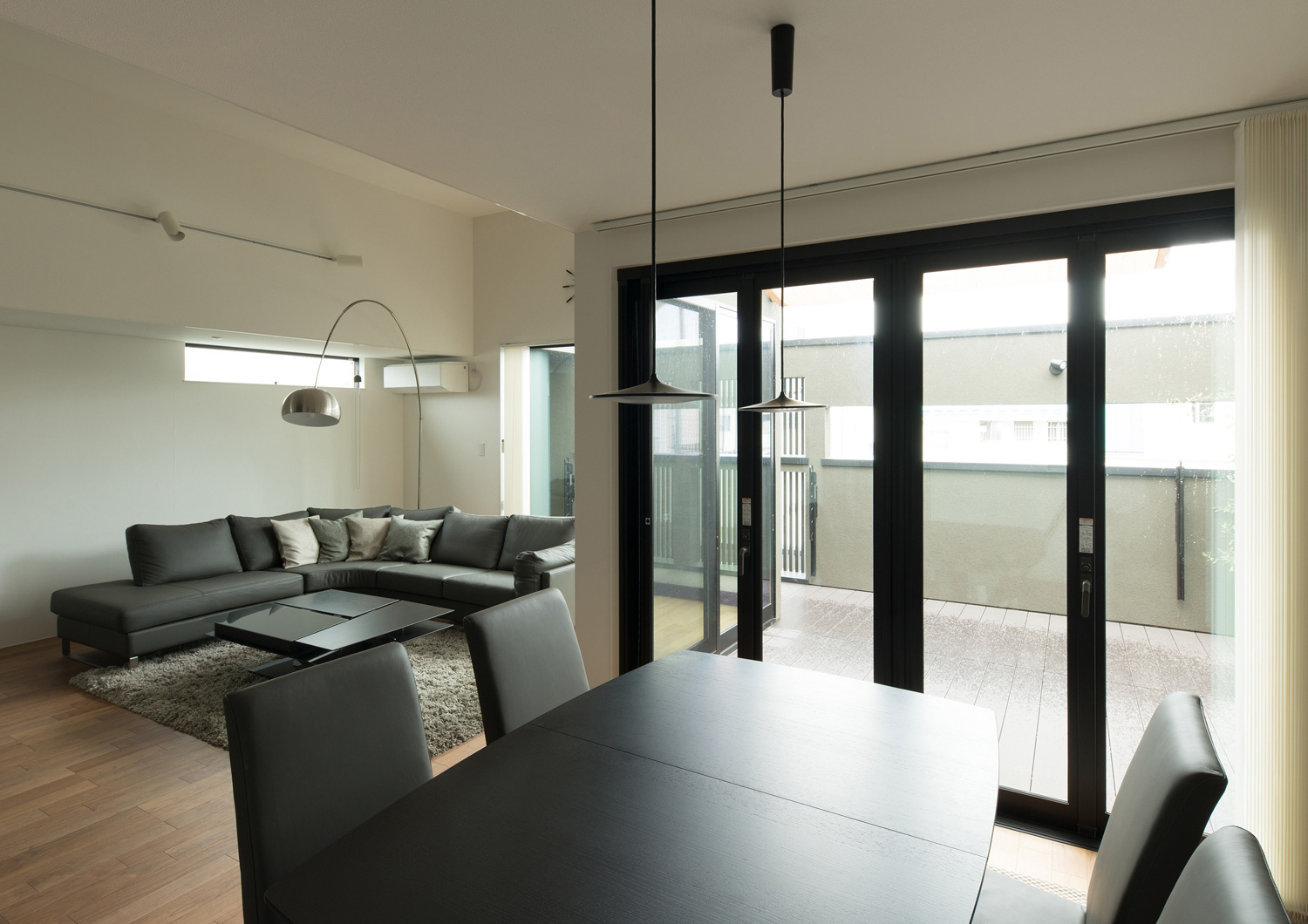 ダイニングテーブルから目隠し壁付きのバルコニーが見える様子・デザイン住宅 注文住宅・デザイン住宅建築実例_『CASE577 紬(つむぎ)の家』_LDK