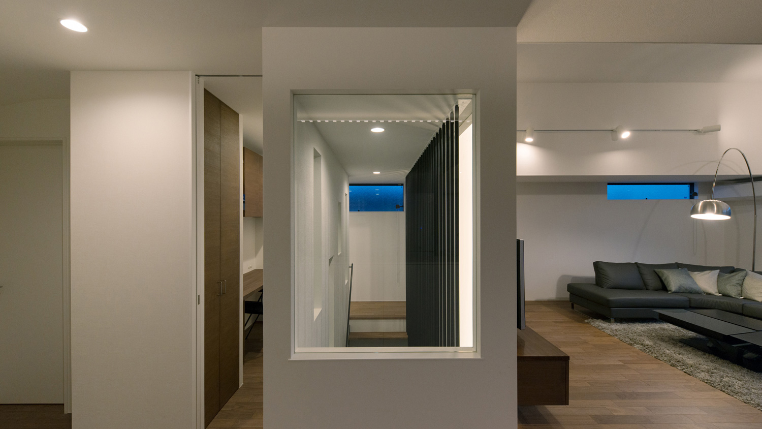 ダウンライトに照らされる、壁に一部がガラスになった階段室・デザイン住宅 注文住宅・デザイン住宅建築実例_『CASE577 紬(つむぎ)の家』_LDK