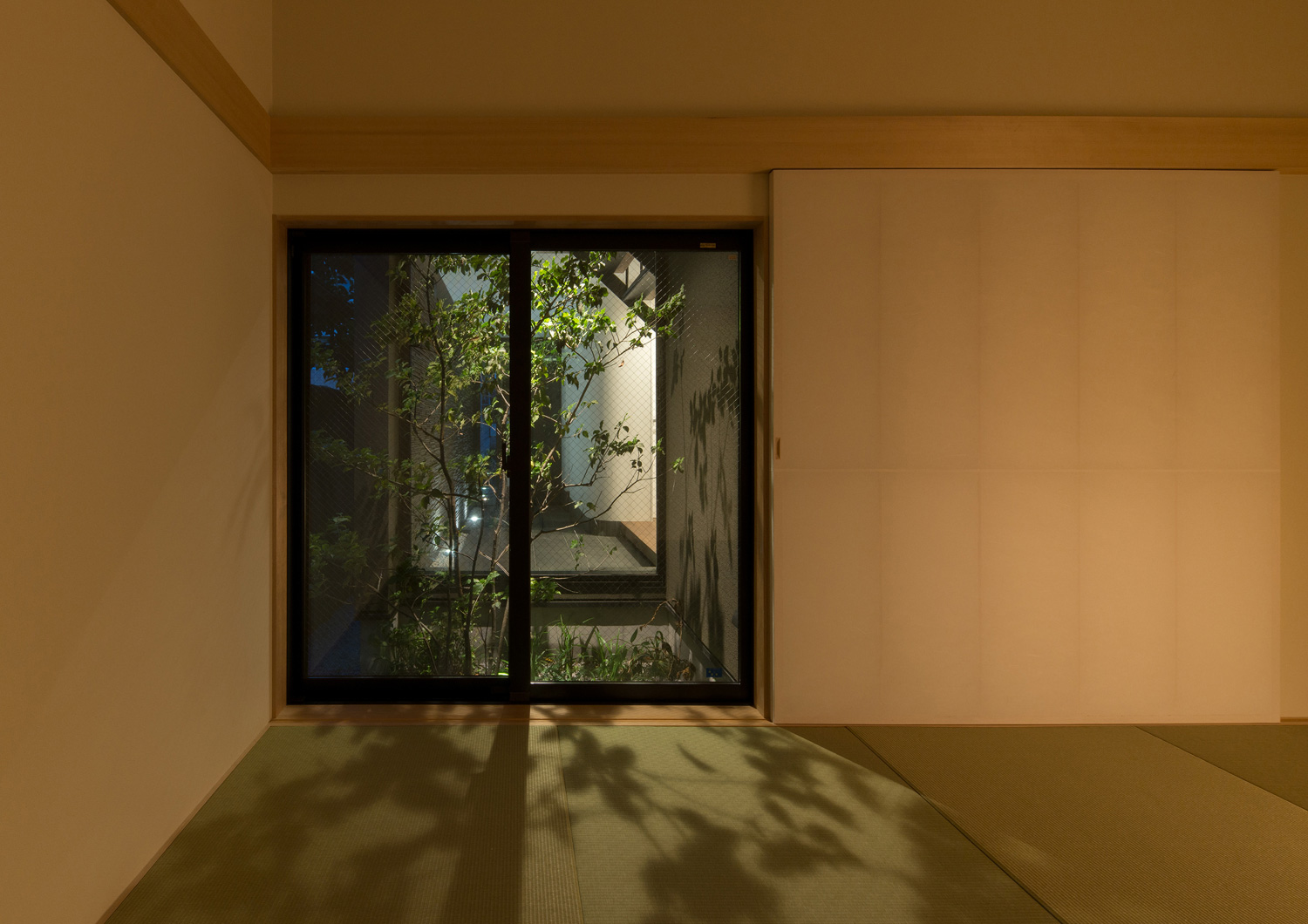 ライトアップされた植栽の影が映し出される琉球畳の和室・デザイン住宅 注文住宅・デザイン住宅建築実例_『CASE577 紬(つむぎ)の家』_和室