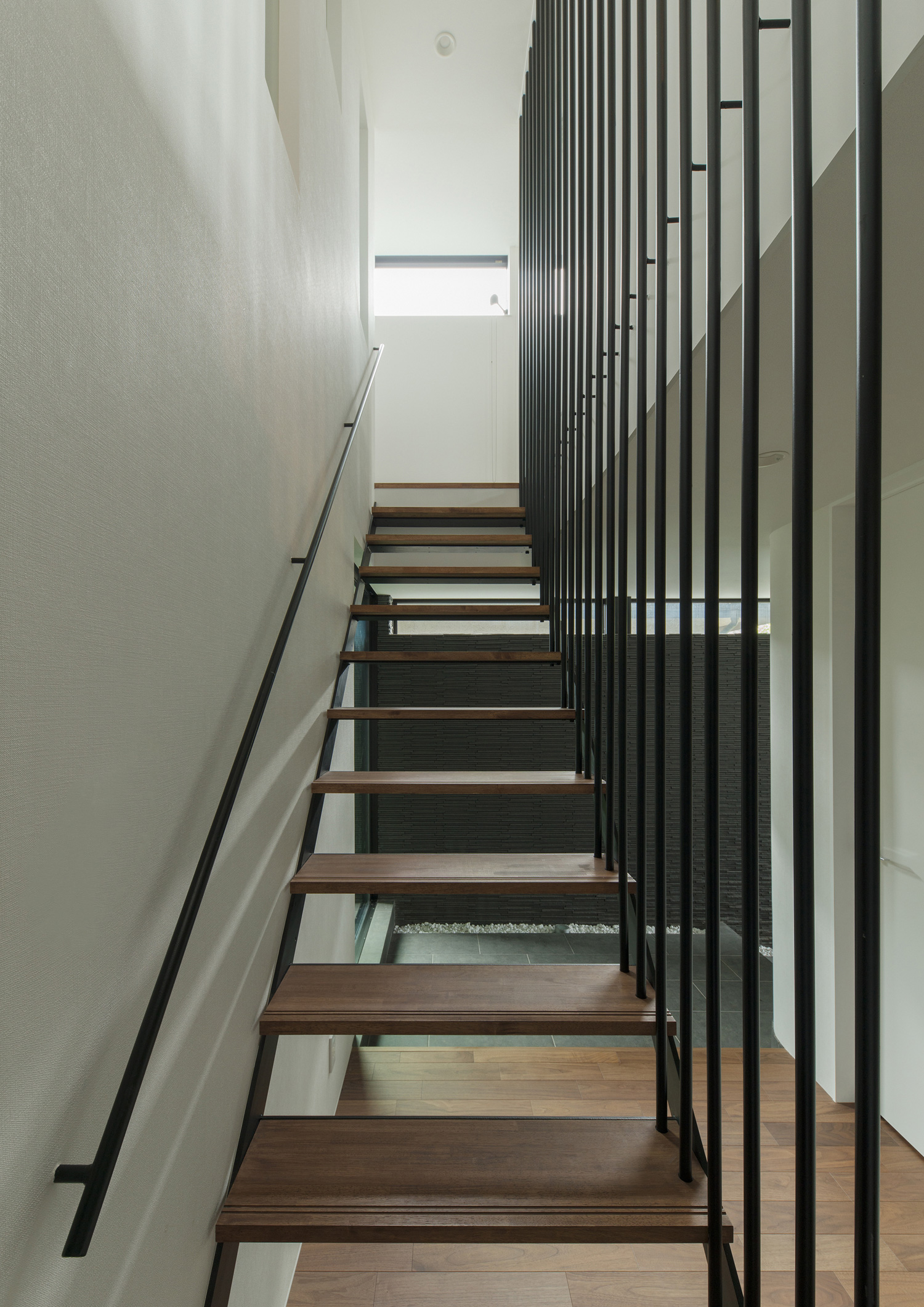 正面に小窓があるアイアンの手すり付きの木製のスケルトン階段・デザイン住宅 注文住宅・デザイン住宅建築実例_『CASE577 紬(つむぎ)の家』_階段
